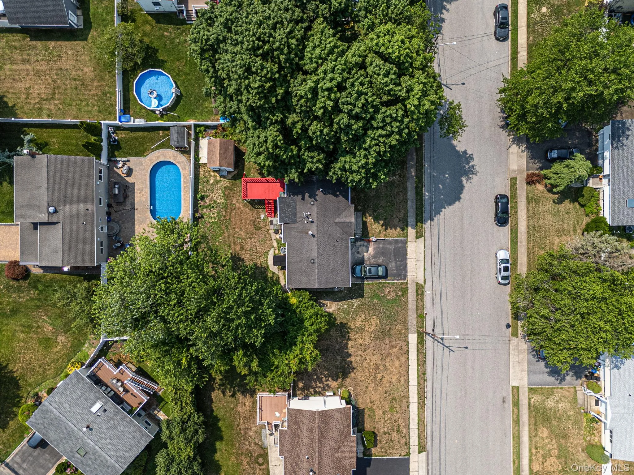Rear yard featuring an in-ground swimming pool with surrounding patio, a detached shed, and mature perimeter trees Rear yard featuring an in-ground swimming pool with surrounding patio, a detached shed, and mature perimeter trees