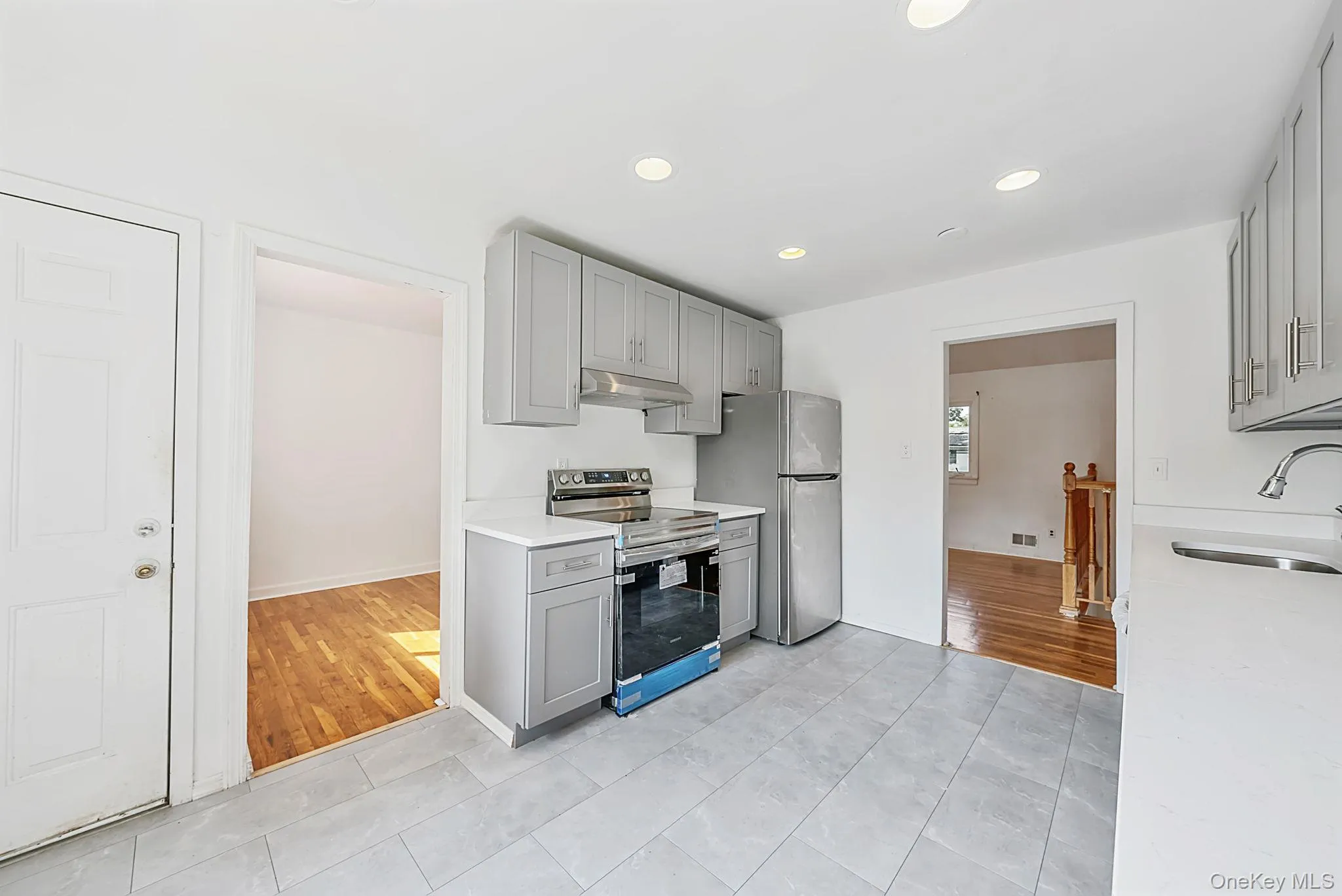 Kitchen featuring light gray cabinetry, stainless steel appliances, white countertops, and recessed lighting Kitchen featuring light gray cabinetry, stainless steel appliances, white countertops, and recessed lighting