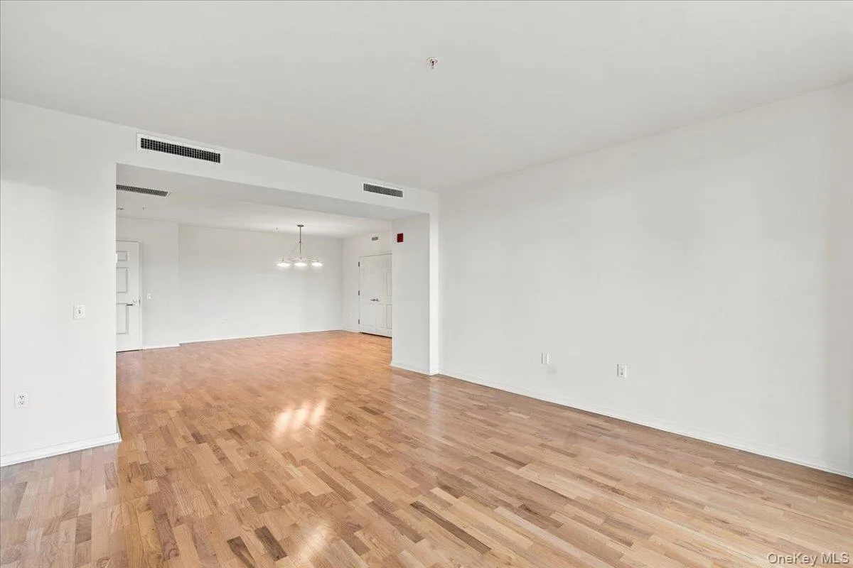 Open-concept interior featuring wood flooring and white walls Open-concept interior featuring wood flooring and white walls
