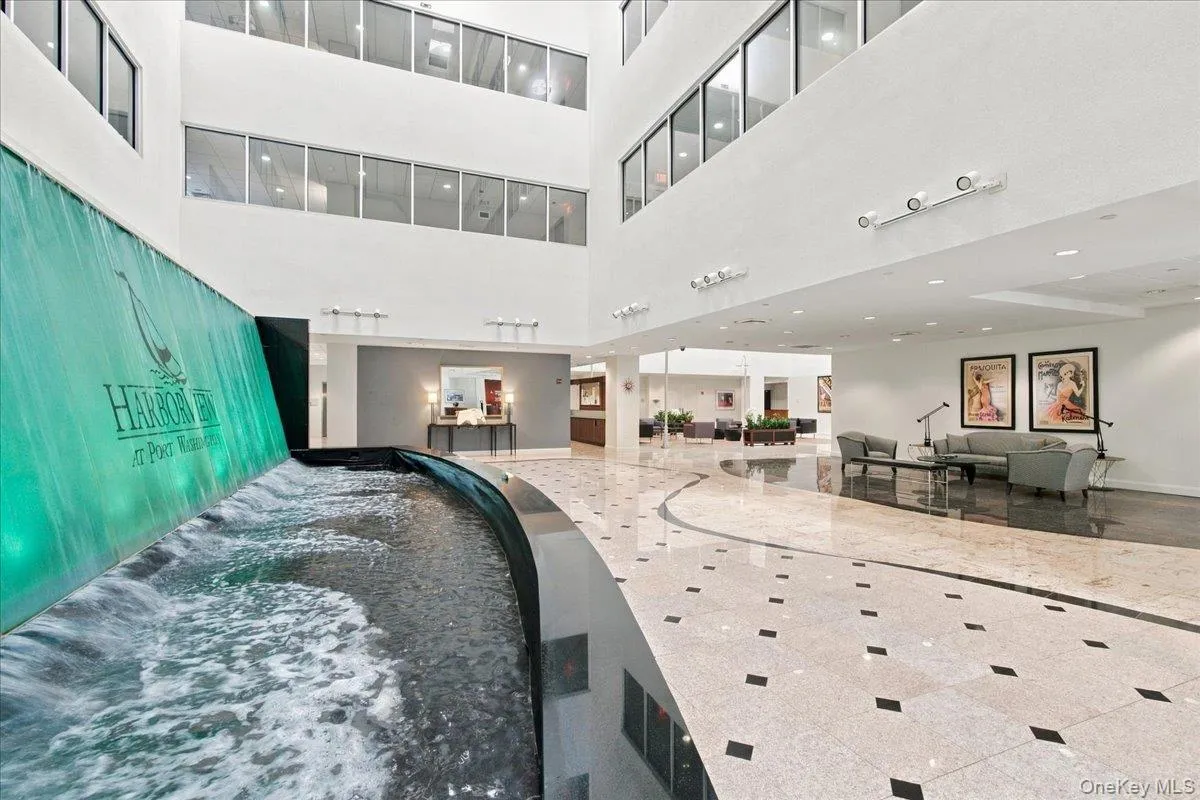 Entrance Foyer interior atrium with an illuminated water feature, polished stone flooring, and multiple seating areas Entrance Foyer interior atrium with an illuminated water feature, polished stone flooring, and multiple seating areas
