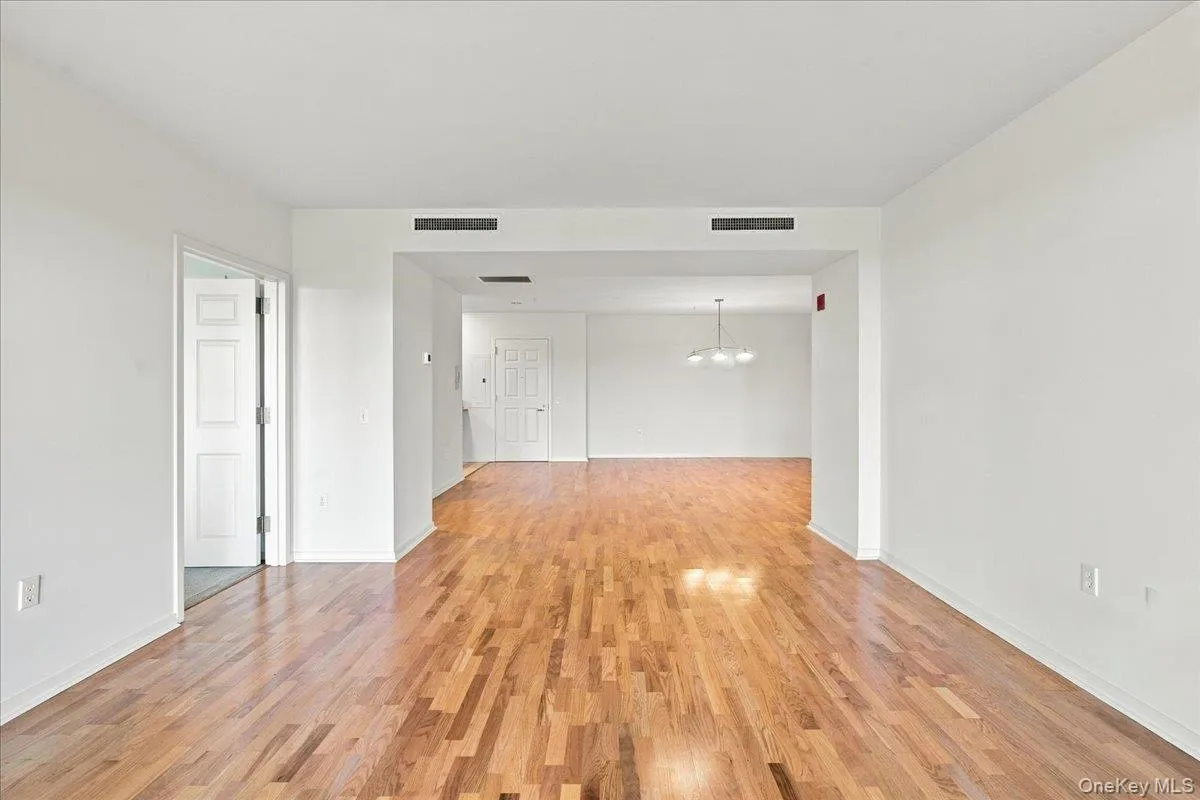 Hardwood flooring throughout, white painted walls, recessed lighting, and a contemporary pendant light fixture Hardwood flooring throughout, white painted walls, recessed lighting, and a contemporary pendant light fixture