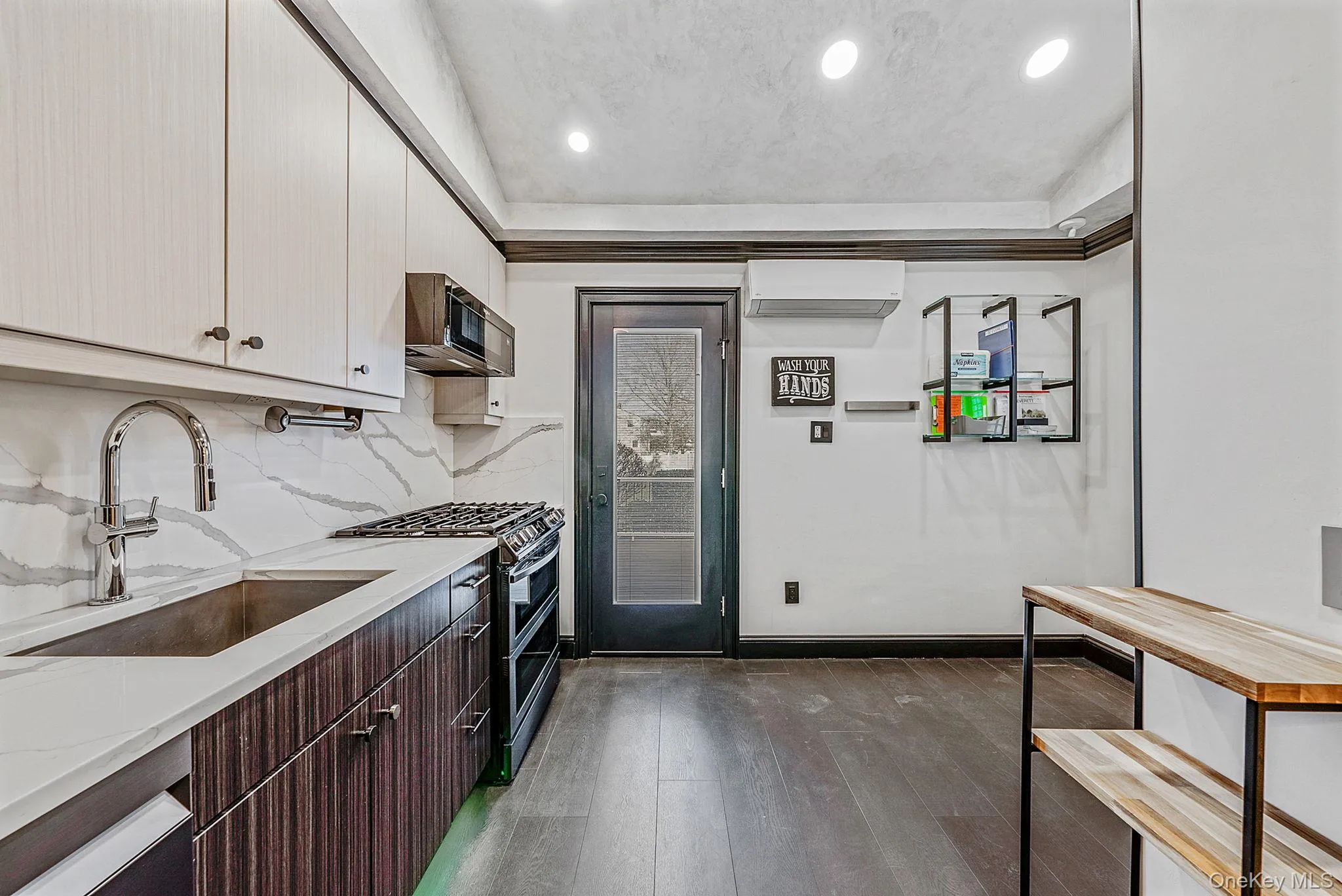 Kitchen with double oven range, dark brown cabinets, modern cabinets, dark wood-style floors, and recessed lighting Kitchen with double oven range, dark brown cabinets, modern cabinets, dark wood-style floors, and recessed lighting