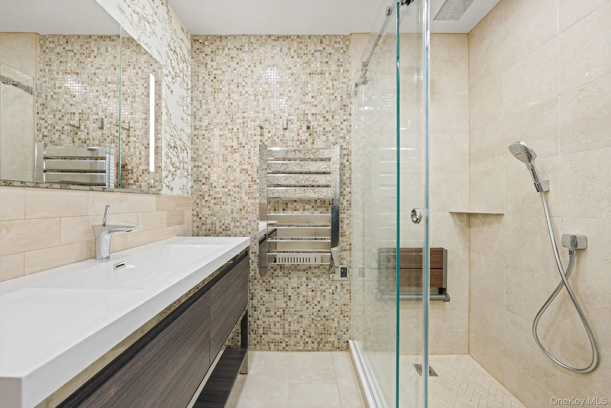 Full bathroom with a stall shower, vanity, tile walls, a towel warmer, and light tile patterned flooring Full bathroom with a stall shower, vanity, tile walls, a towel warmer, and light tile patterned flooring