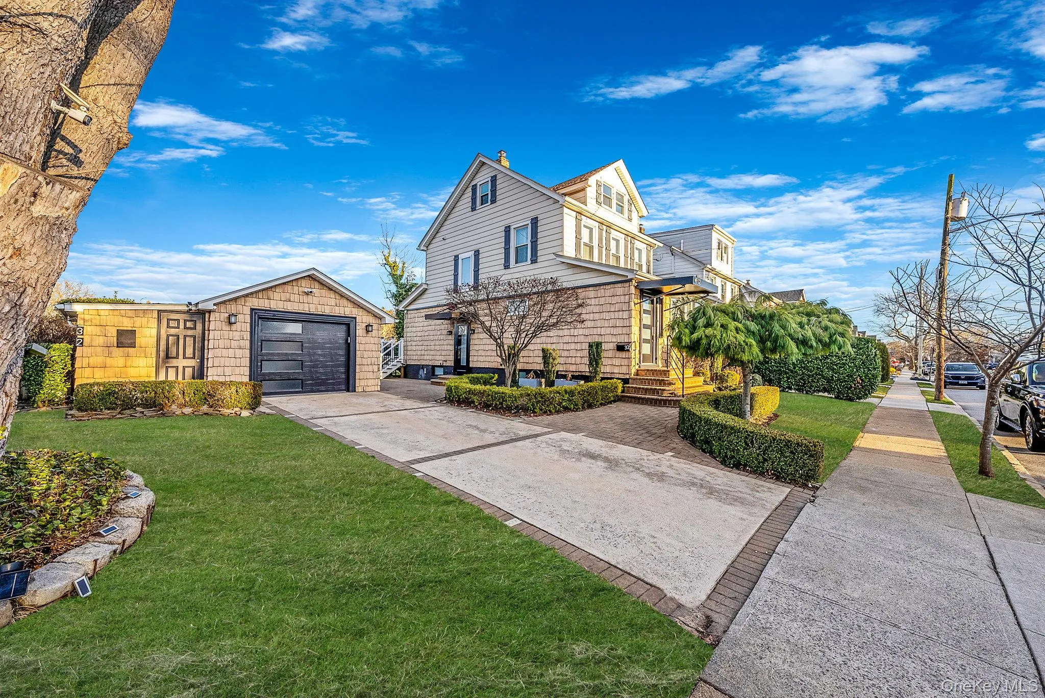 View of side of home with an outdoor structure, a yard, driveway, and a garage View of side of home with an outdoor structure, a yard, driveway, and a garage