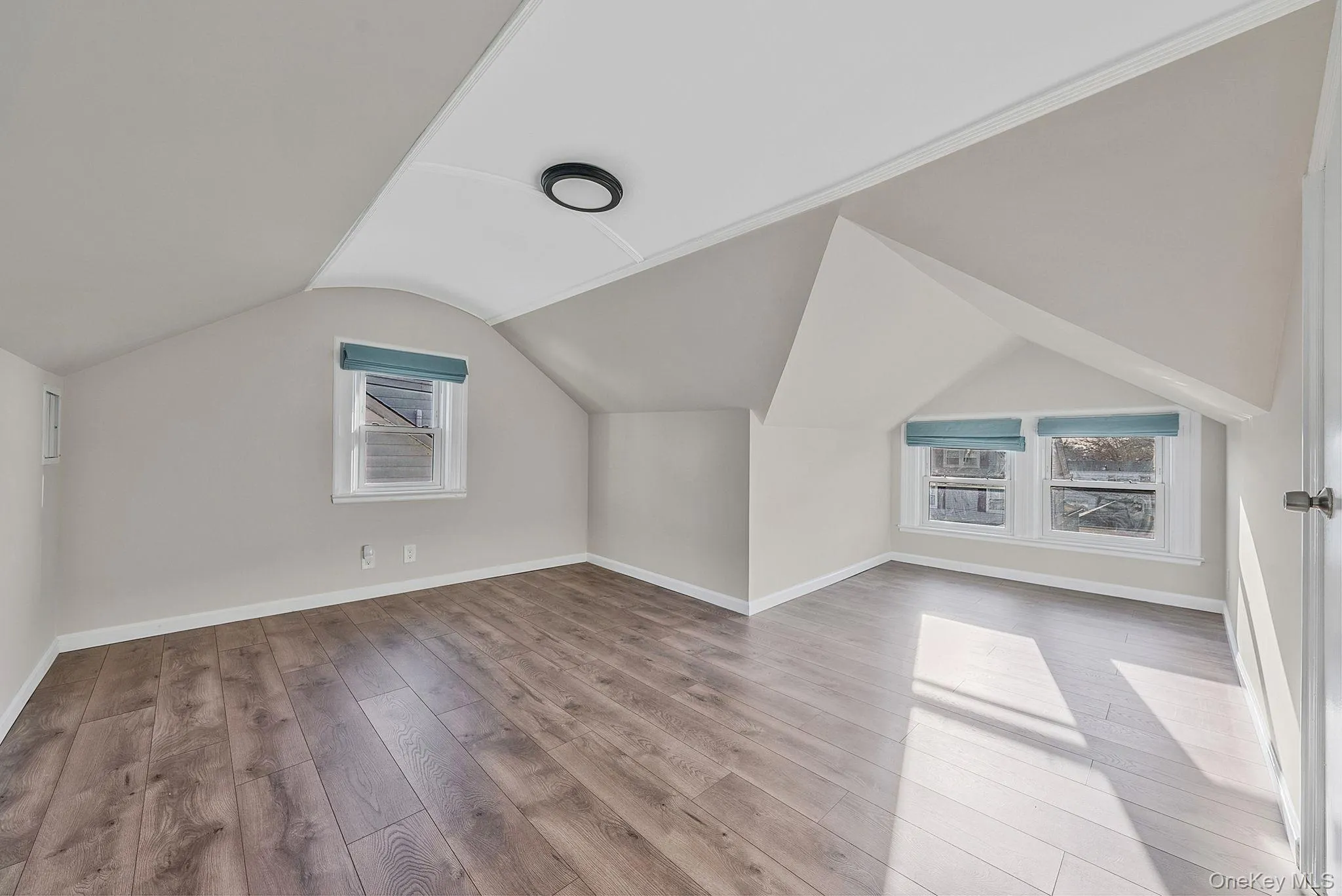 Bonus room with light wood-style floors and vaulted ceiling Bonus room with light wood-style floors and vaulted ceiling
