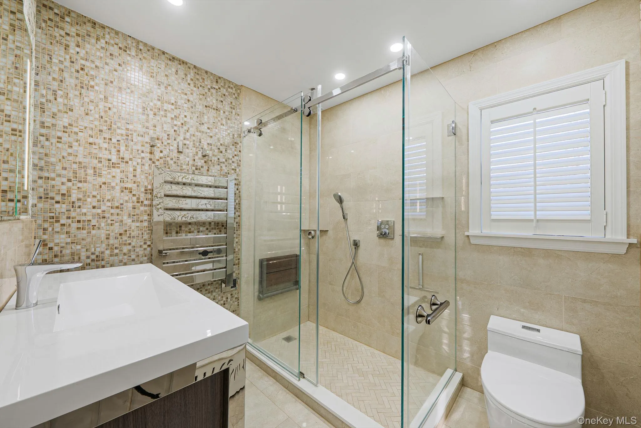 Bathroom with tile walls, vanity, a stall shower, recessed lighting, and light tile patterned flooring Bathroom with tile walls, vanity, a stall shower, recessed lighting, and light tile patterned flooring