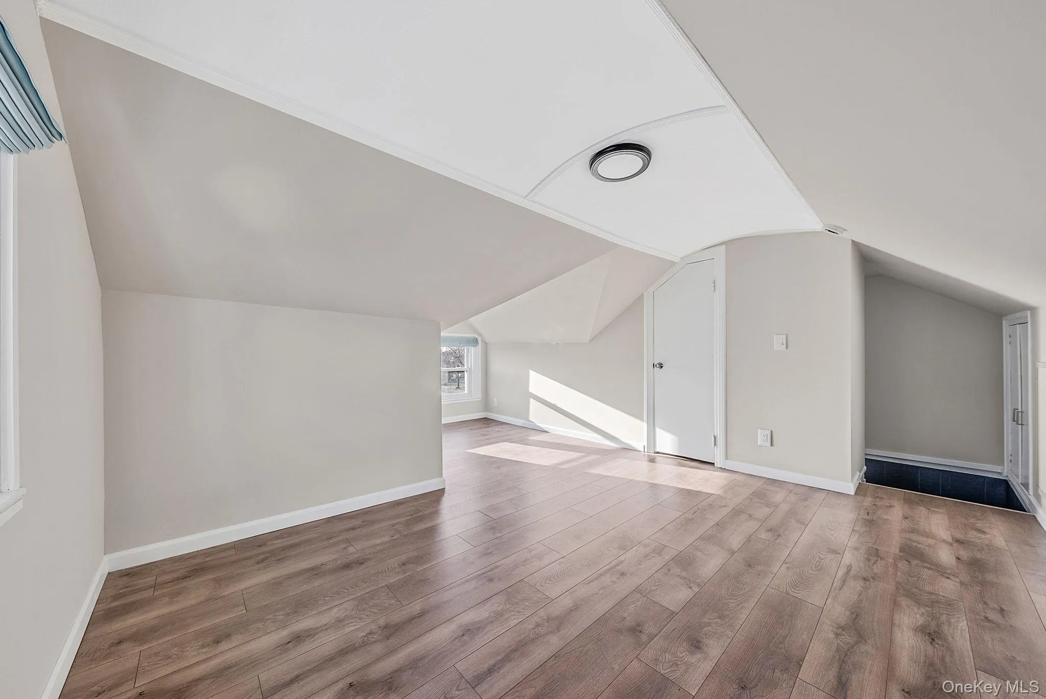 Bonus room featuring light wood-type flooring and lofted ceiling Bonus room featuring light wood-type flooring and lofted ceiling