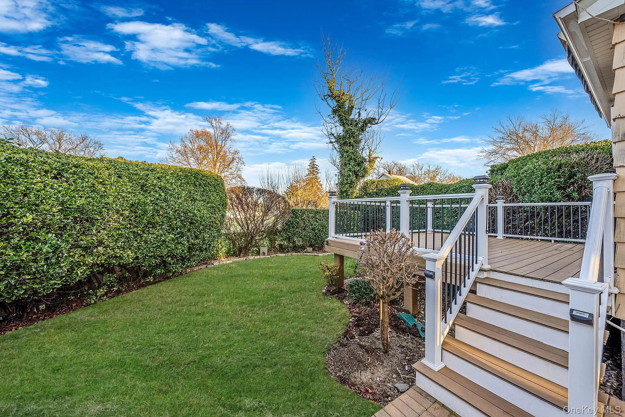 View of grassy yard featuring a deck and stairway View of grassy yard featuring a deck and stairway