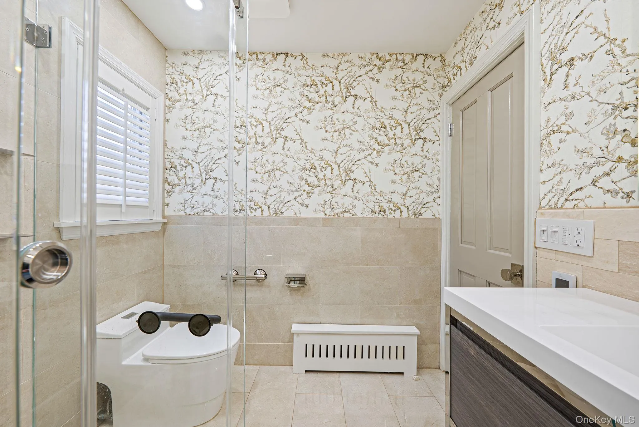 Full bathroom featuring a wainscoted wall, radiator, tile walls, vanity, and wallpapered walls Full bathroom featuring a wainscoted wall, radiator, tile walls, vanity, and wallpapered walls