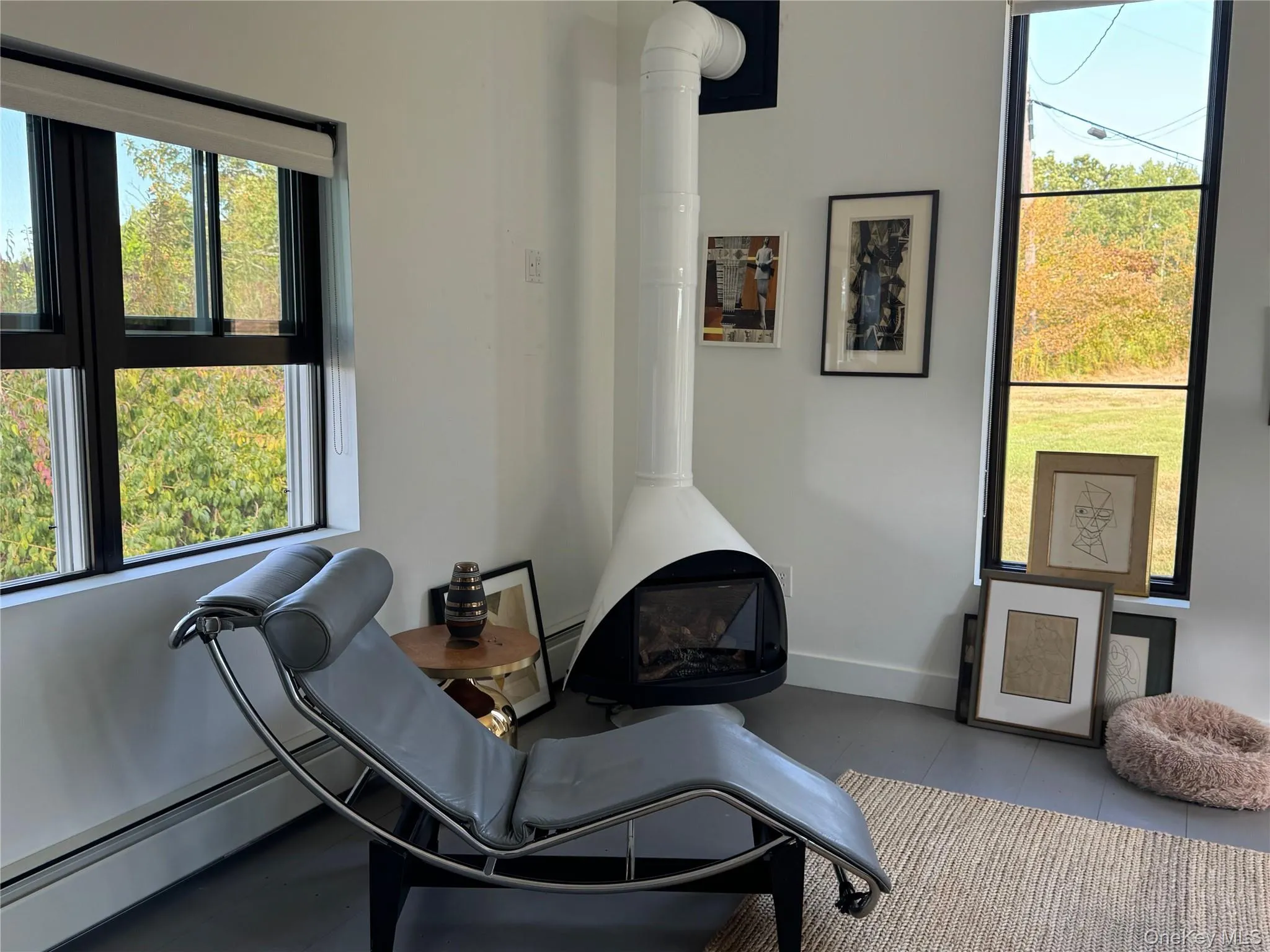 Sitting room with a wood stove, a baseboard heating unit, and tile patterned floors Sitting room with a wood stove, a baseboard heating unit, and tile patterned floors