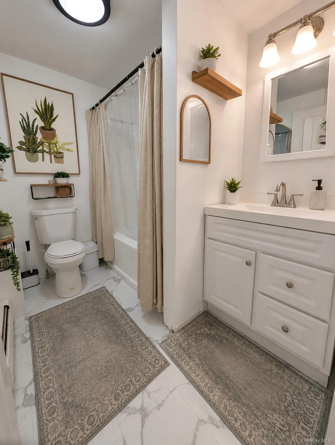 White bathroom featuring a single vanity with storage cabinetry, a recessed sink, and a framed mirror White bathroom featuring a single vanity with storage cabinetry, a recessed sink, and a framed mirror