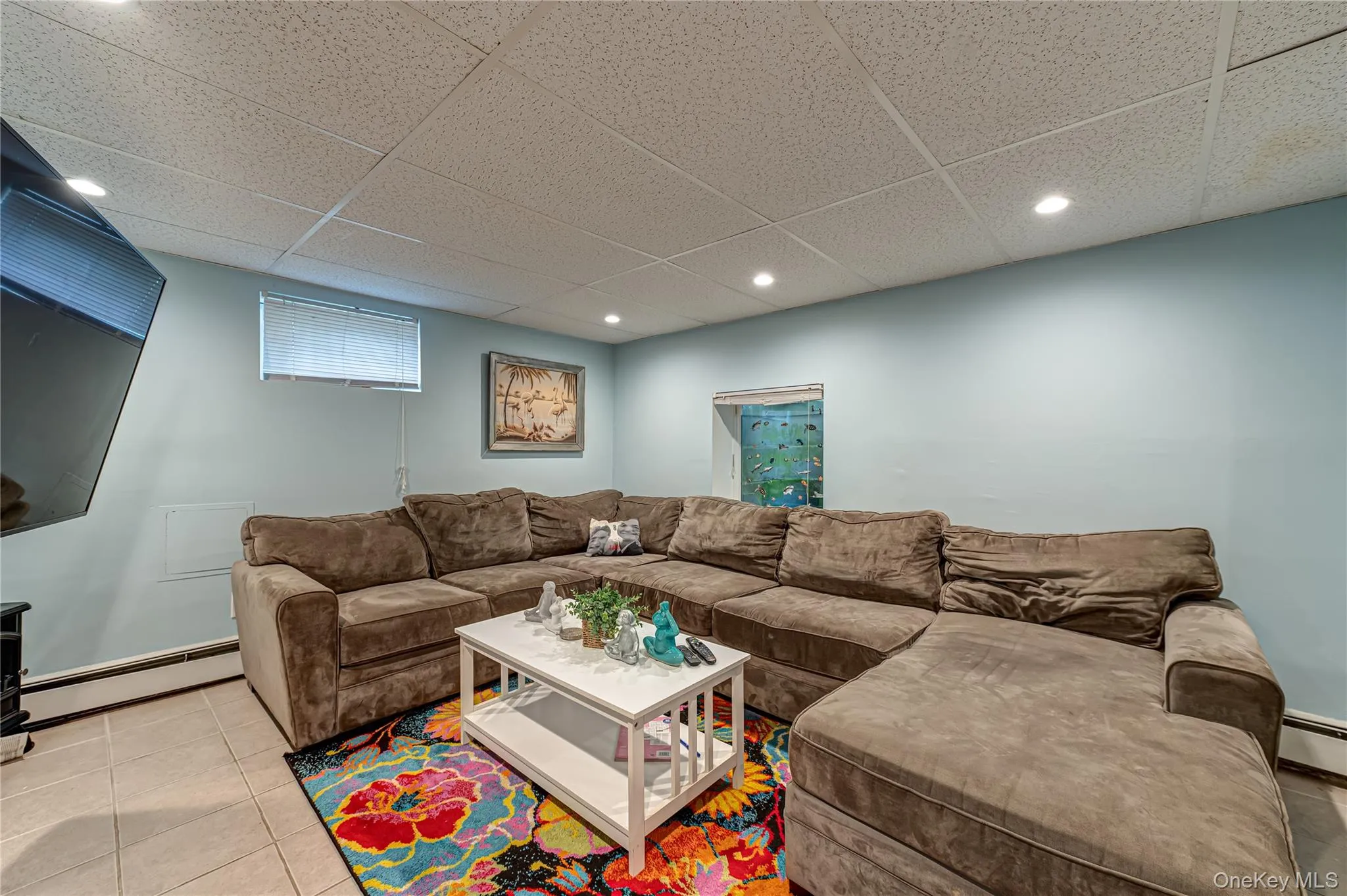 Recreational room featuring light blue wall, egress window and recessed lighting Recreational room featuring light blue wall, egress window and recessed lighting