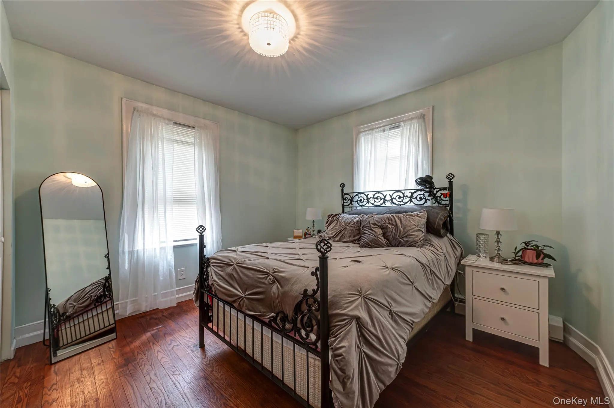 Wood-finish flooring throughout, complemented by a decorative ceiling light fixture Wood-finish flooring throughout, complemented by a decorative ceiling light fixture