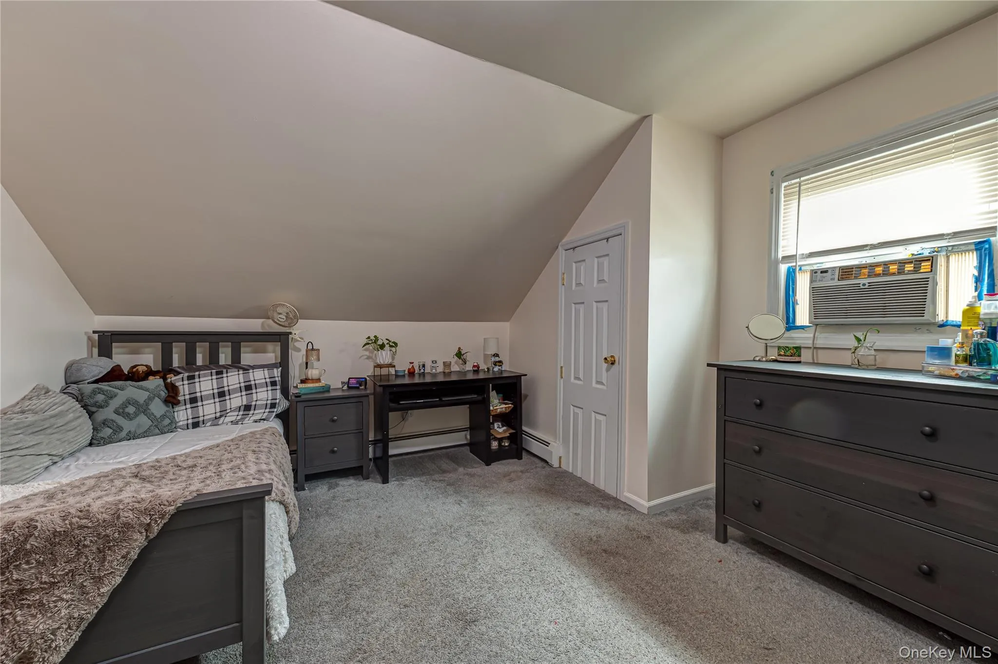 Carpeted room featuring a white paneled door, sloped ceiling, on 2nd floor Carpeted room featuring a white paneled door, sloped ceiling, on 2nd floor