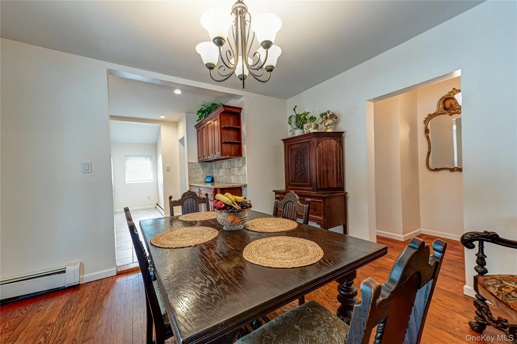 Dining area featuring wood-finish flooring and a decorative chandelier Dining area featuring wood-finish flooring and a decorative chandelier