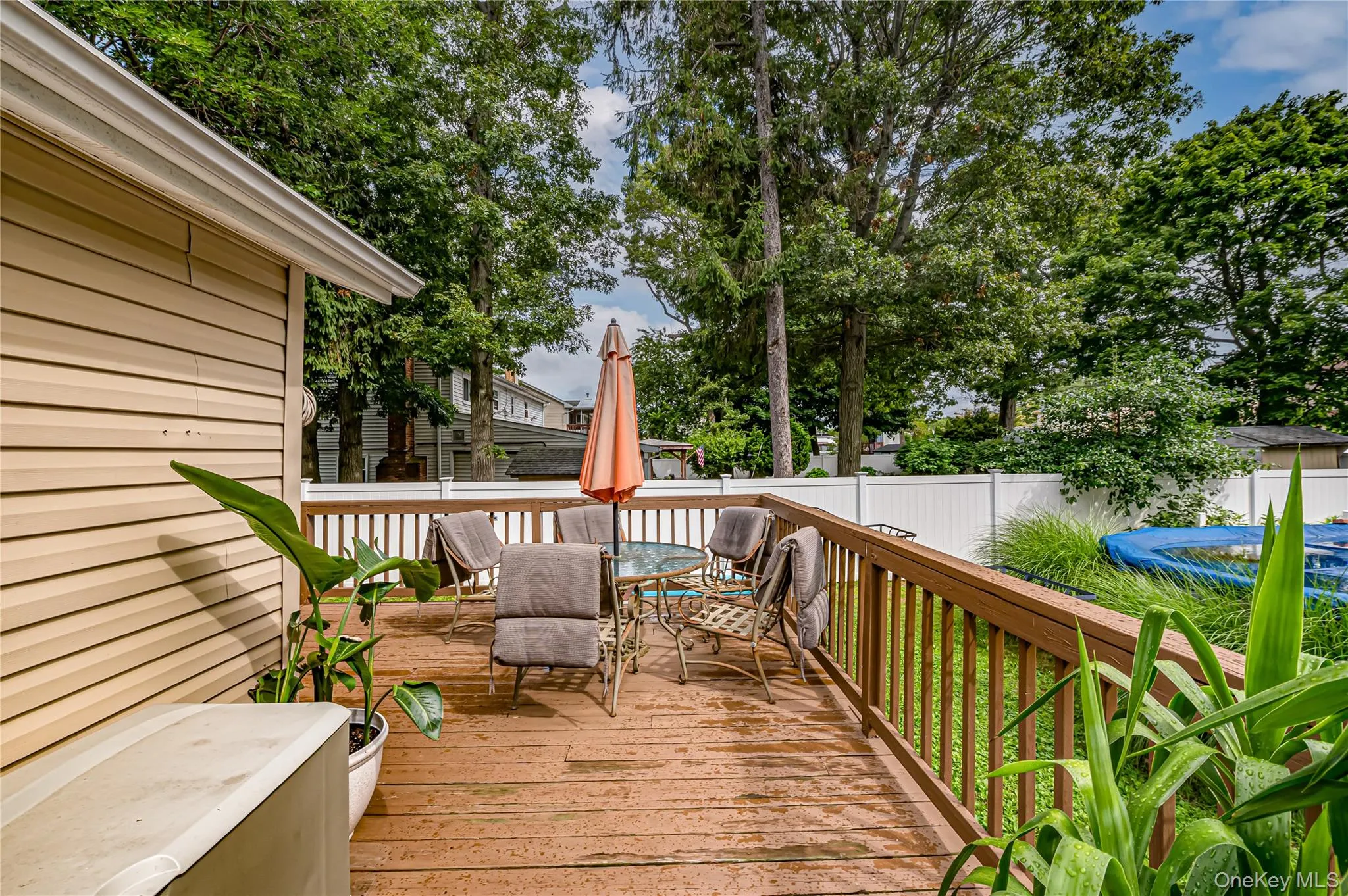 Expansive wood-finish deck featuring a slatted railing and a privacy fence Expansive wood-finish deck featuring a slatted railing and a privacy fence