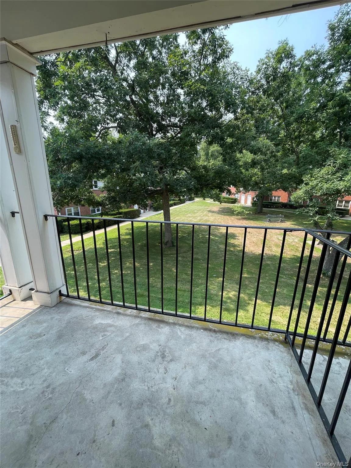 Private balcony featuring a concrete floor and black metal railings Private balcony featuring a concrete floor and black metal railings