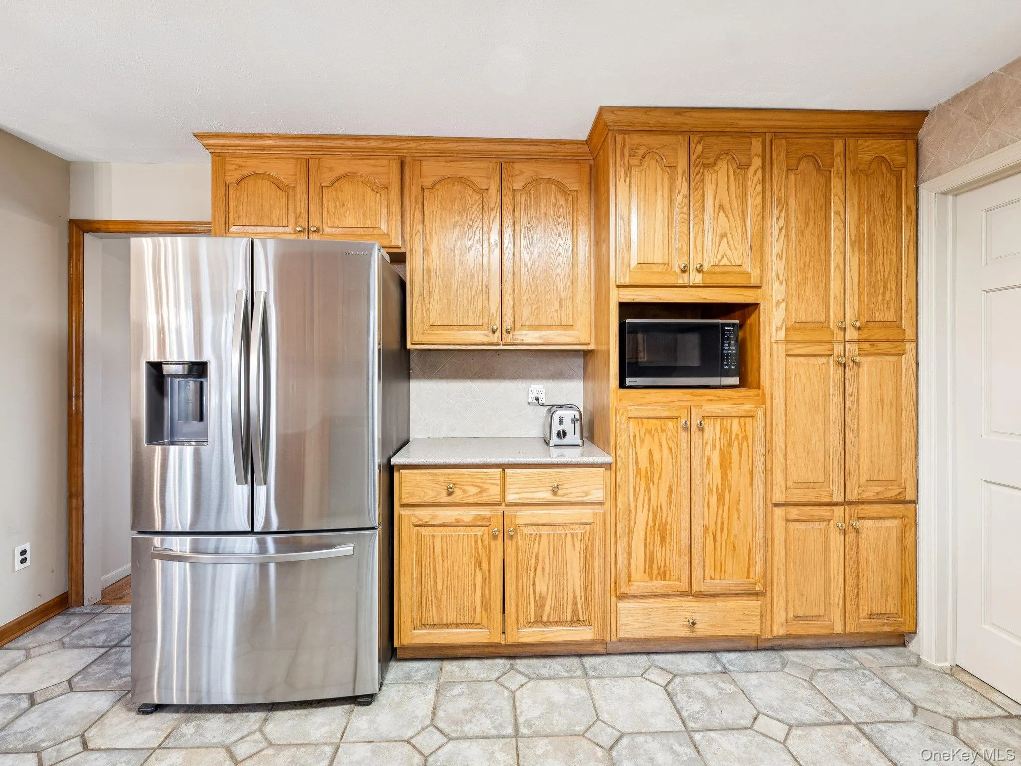 Kitchen with stainless steel appliances, light countertops, and brown cabinets Kitchen with stainless steel appliances, light countertops, and brown cabinets