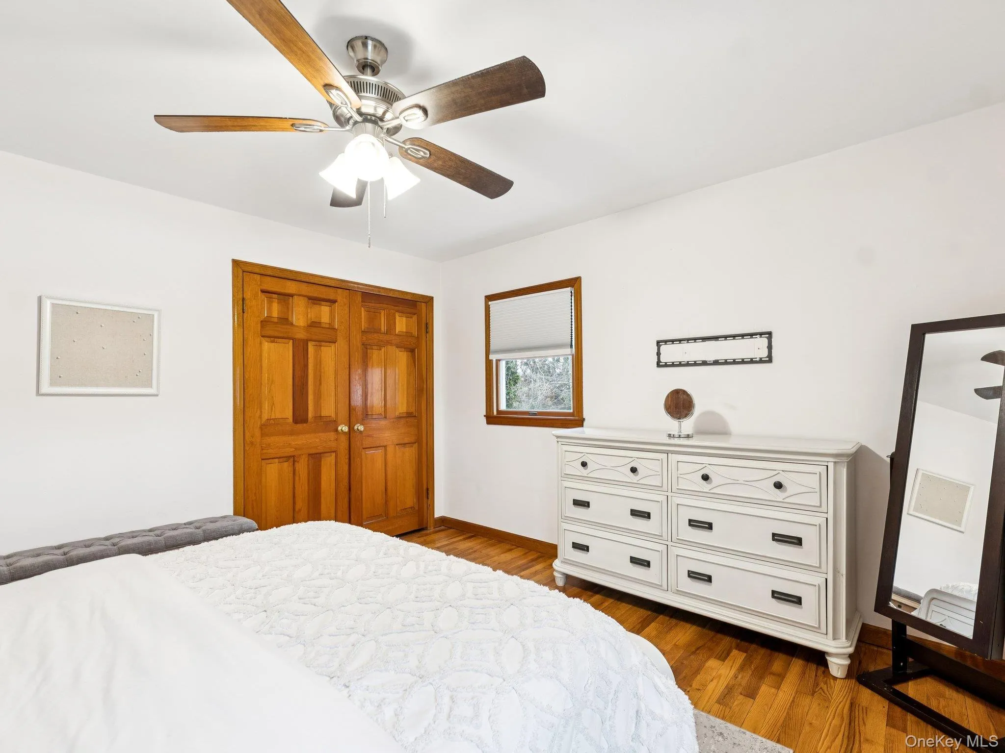Bedroom with light wood-style flooring, a ceiling fan, and a closet Bedroom with light wood-style flooring, a ceiling fan, and a closet
