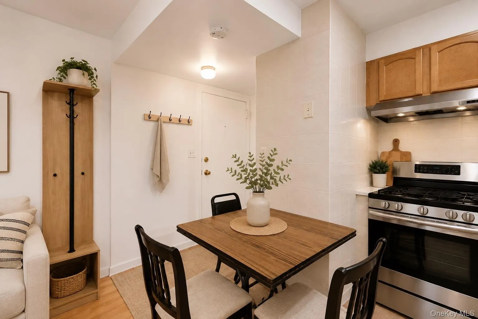 Compact kitchen with stainless steel range and range hood, wood-finish cabinetry, and tiled backsplash. Compact kitchen with stainless steel range and range hood, wood-finish cabinetry, and tiled backsplash.