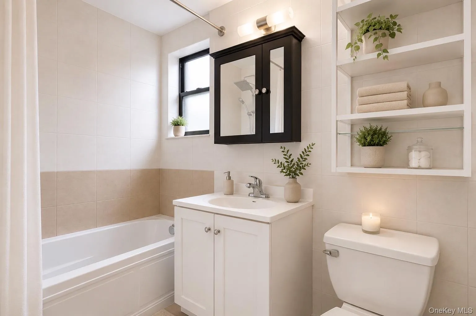 White ceramic tile surround, white vanity with integrated sink, black framed medicine cabinet with mirrored doors, built-in shelving, and a single window. White ceramic tile surround, white vanity with integrated sink, black framed medicine cabinet with mirrored doors, built-in shelving, and a single window.