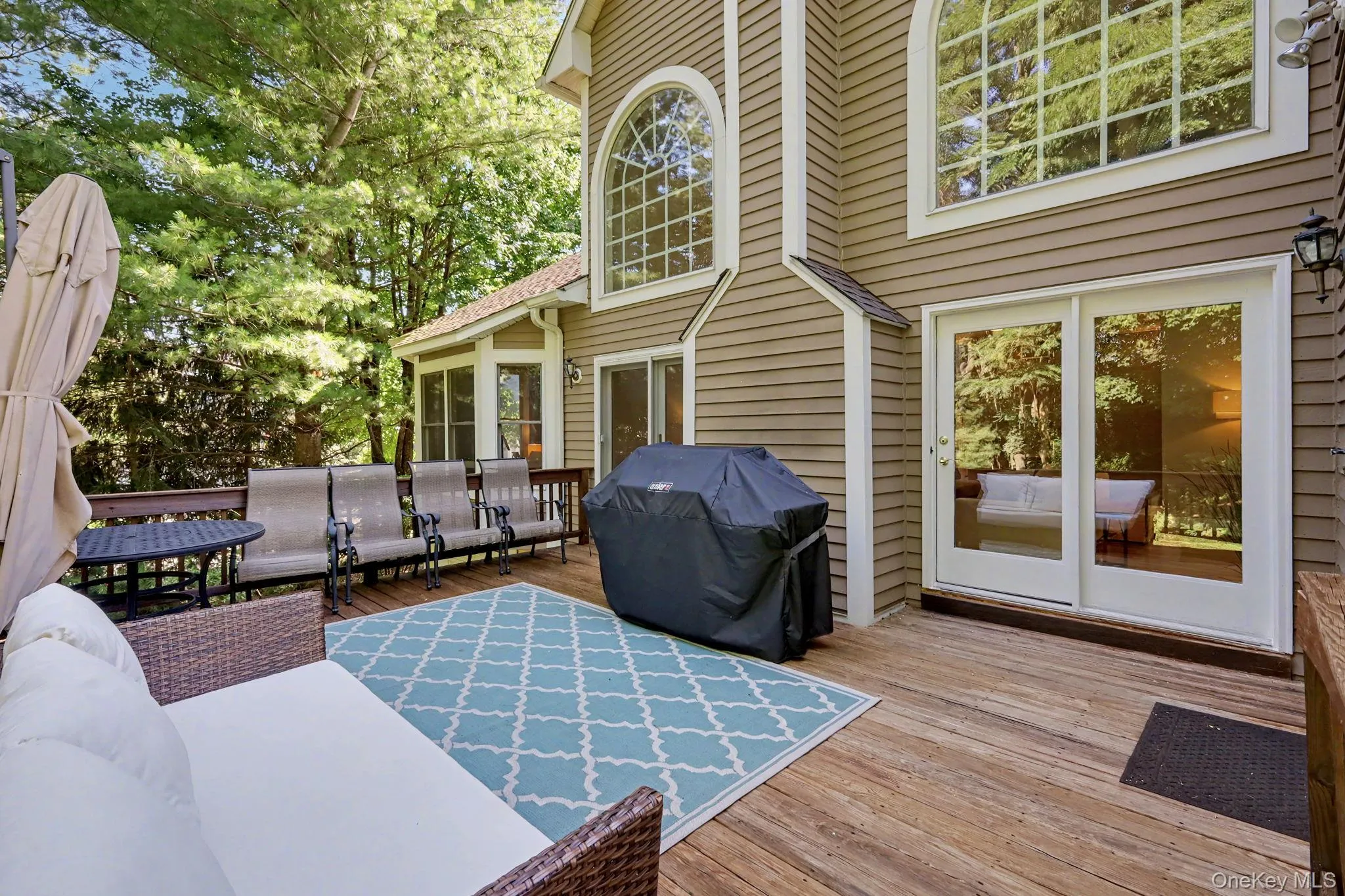 Expansive wooden deck featuring multiple sliding glass doors. Expansive wooden deck featuring multiple sliding glass doors.