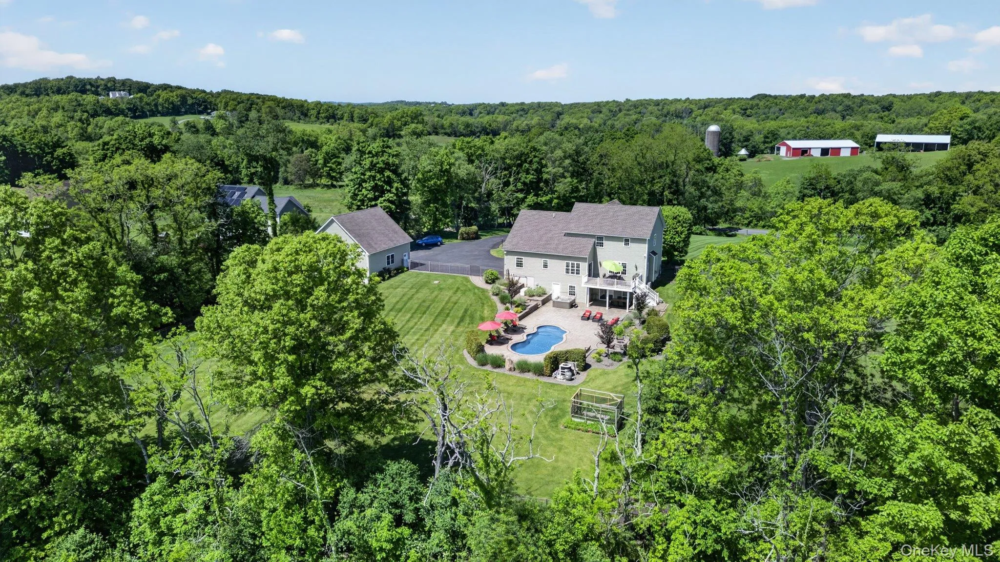 Expansive property featuring a large residence, detached garage, and a swimming pool with surrounding patio Expansive property featuring a large residence, detached garage, and a swimming pool with surrounding patio