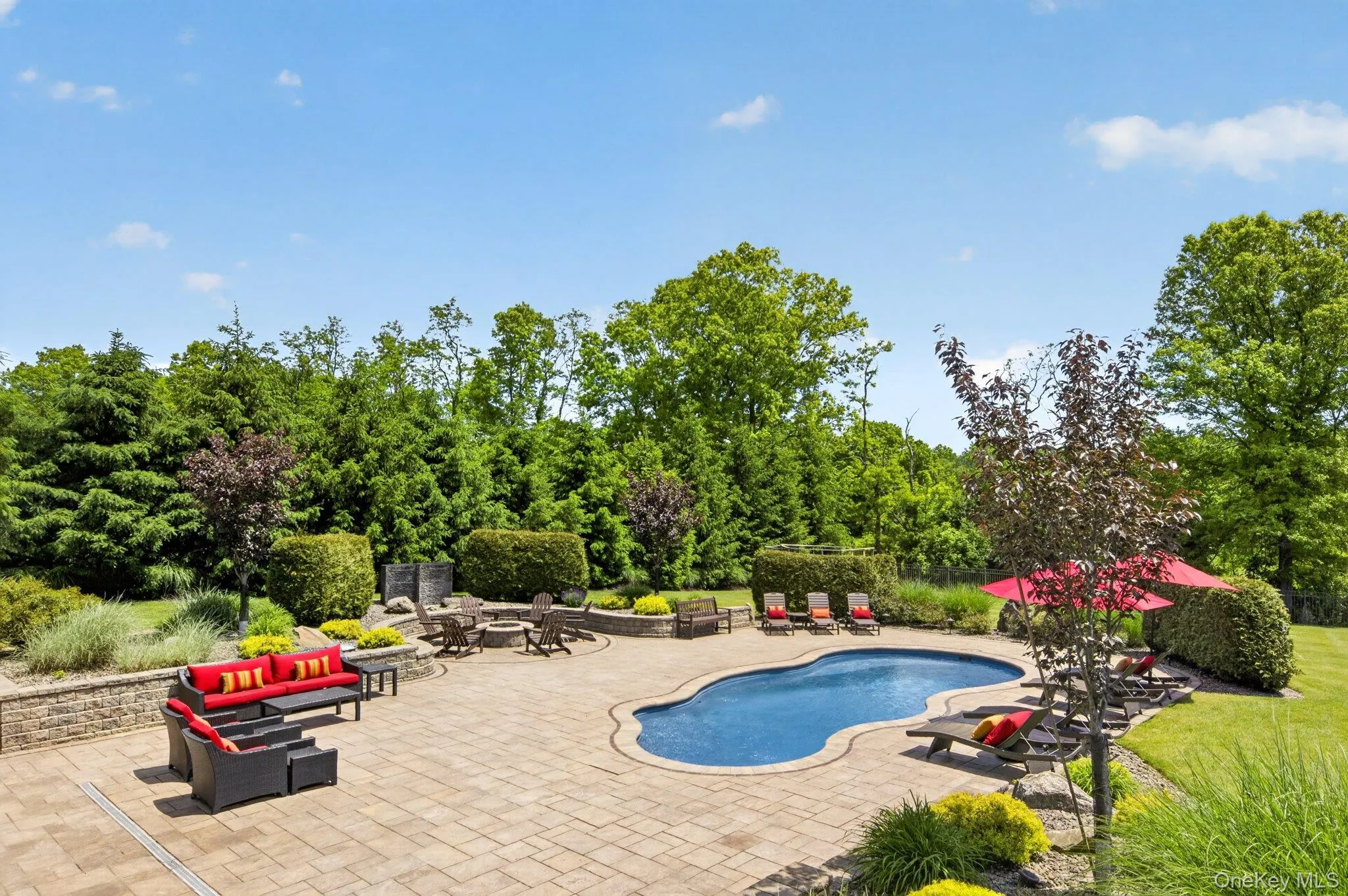 Backyard oasis featuring an in-ground pool with a paver patio surround Backyard oasis featuring an in-ground pool with a paver patio surround