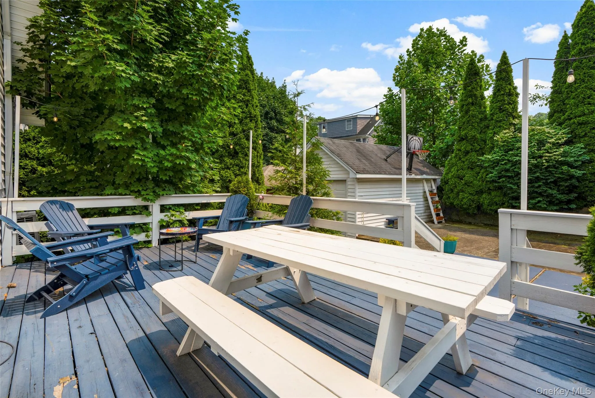 Spacious outdoor deck featuring painted wood flooring and white railings. Spacious outdoor deck featuring painted wood flooring and white railings.