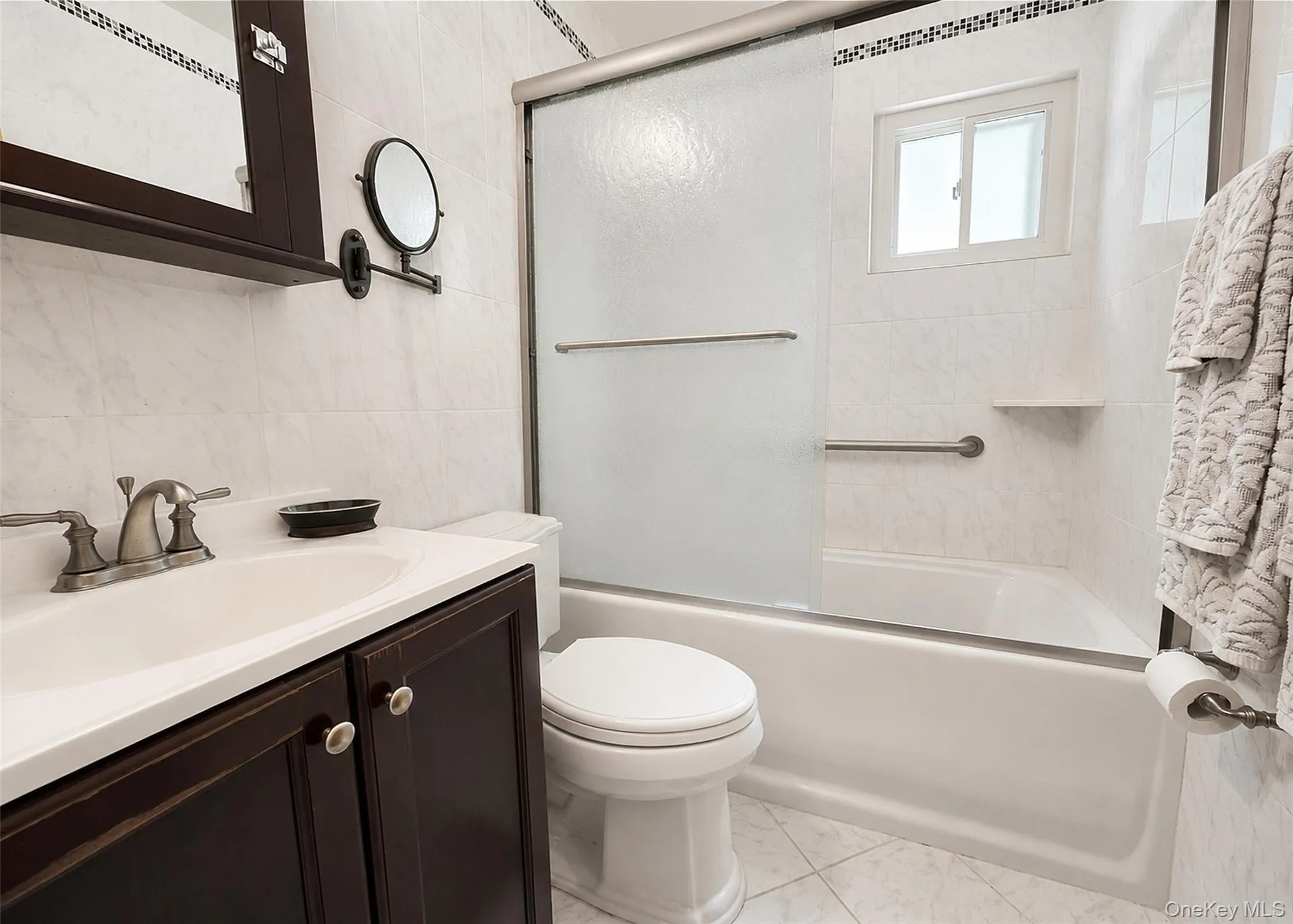Beautifully Updated Full Bath With Tub/Shower Combo & Extensive Tilework Including Deco Mosaic Border. Beautifully Updated Full Bath With Tub/Shower Combo & Extensive Tilework Including Deco Mosaic Border.