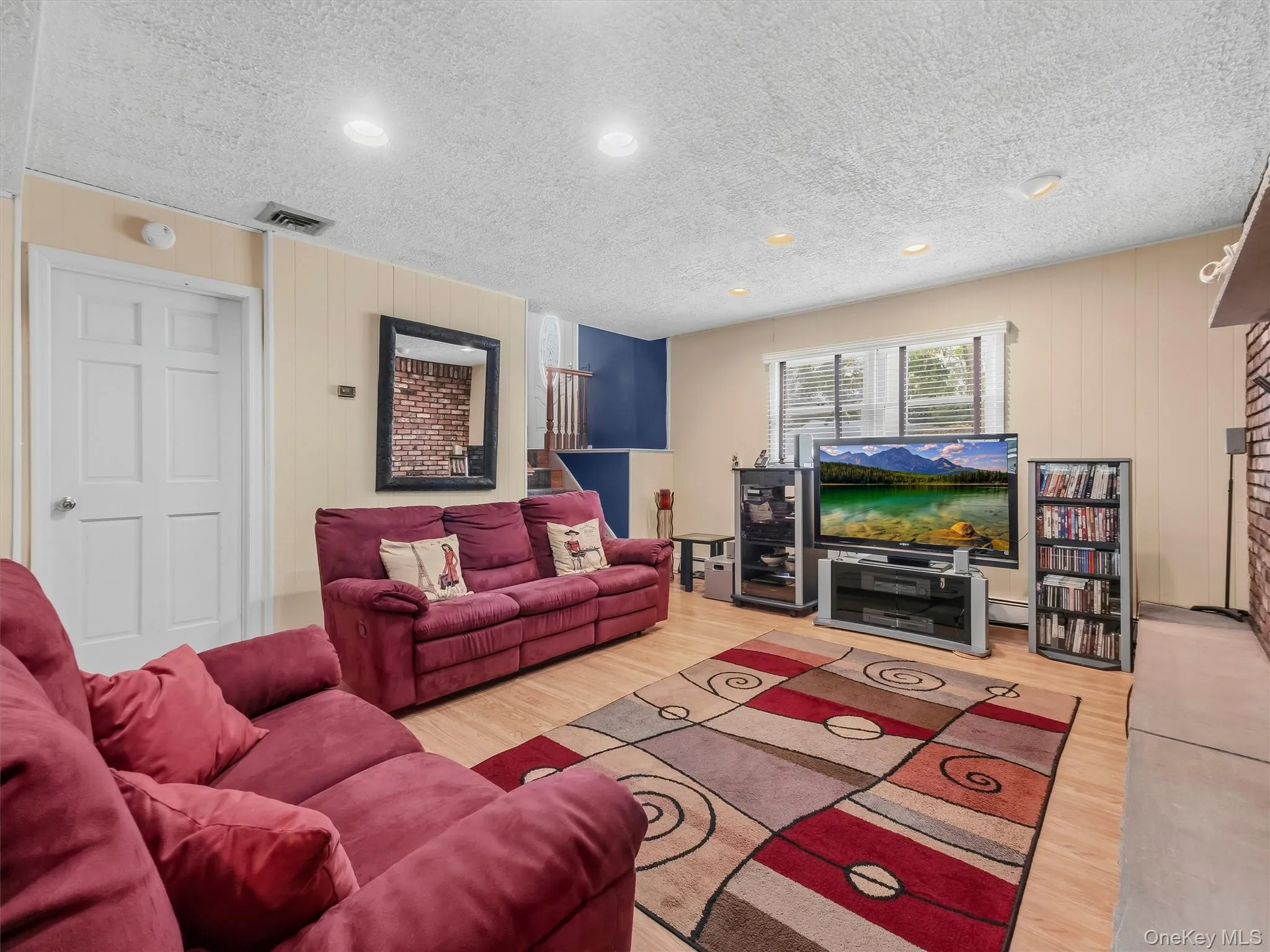 Hardwood-style flooring throughout a spacious room with recessed lighting Hardwood-style flooring throughout a spacious room with recessed lighting
