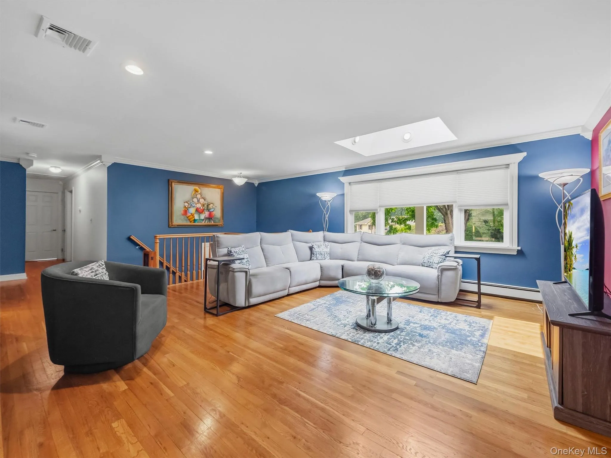 Freshly Painted! Spacious living area featuring hardwood flooring, a vaulted ceiling with skylight, crown moldings and recessed lighting. Freshly Painted! Spacious living area featuring hardwood flooring, a vaulted ceiling with skylight, crown moldings and recessed lighting.
