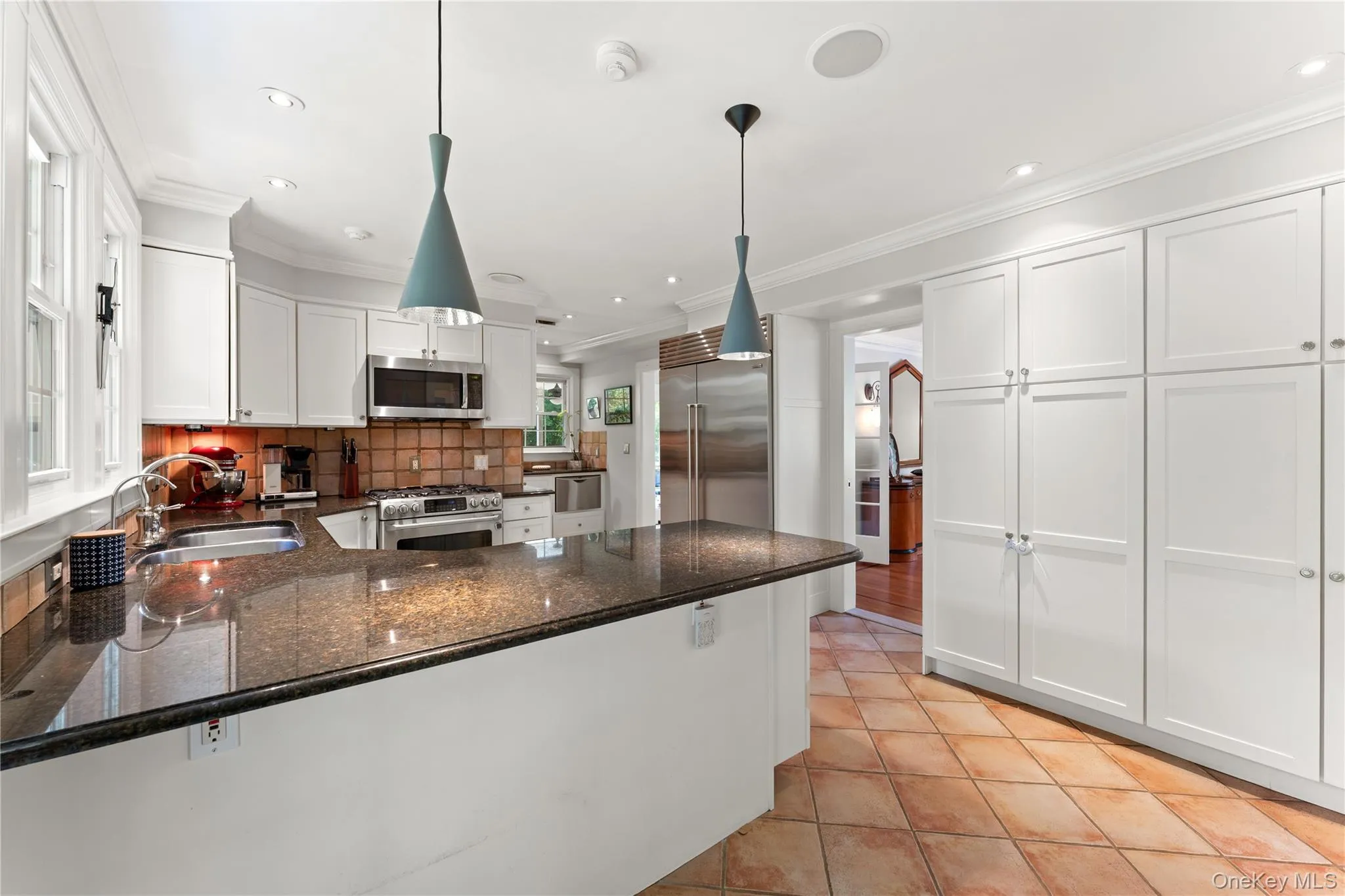 Dine-In Kitchen featuring stainless steel appliances, granite countertops, two sinks, custom cabinetry and access to the yard via the French Door. Dine-In Kitchen featuring stainless steel appliances, granite countertops, two sinks, custom cabinetry and access to the yard via the French Door.