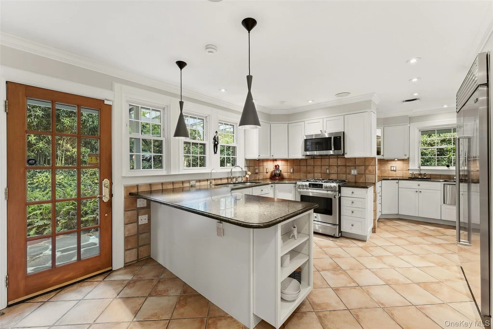 Dine-In Kitchen featuring stainless steel appliances, granite countertops, two sinks, custom cabinetry and access to the yard via the French Door. Dine-In Kitchen featuring stainless steel appliances, granite countertops, two sinks, custom cabinetry and access to the yard via the French Door.