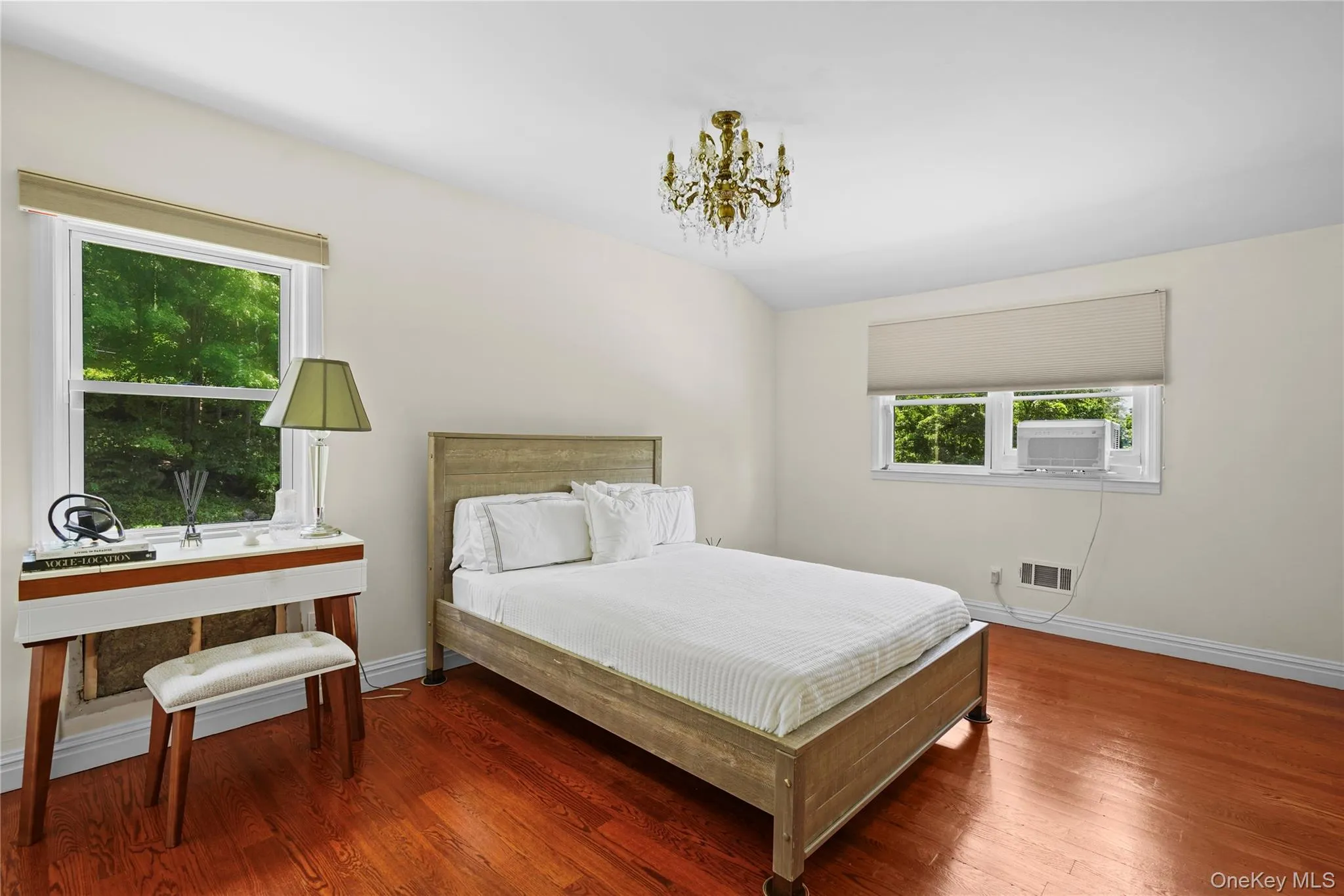 Another angle of the bedroom showcasing windows that fill the space with natural light and gleaming hardwood floors Another angle of the bedroom showcasing windows that fill the space with natural light and gleaming hardwood floors