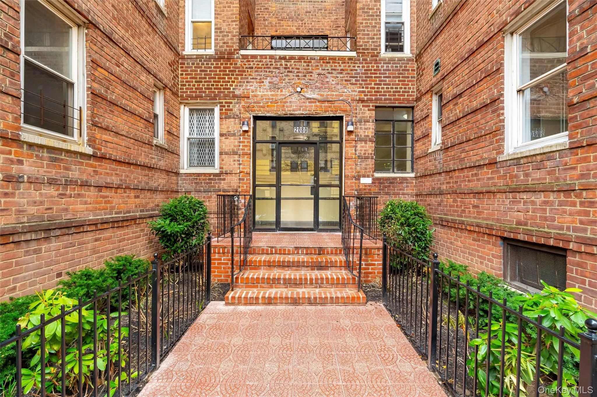 Doorway to property featuring fence and brick siding Doorway to property featuring fence and brick siding
