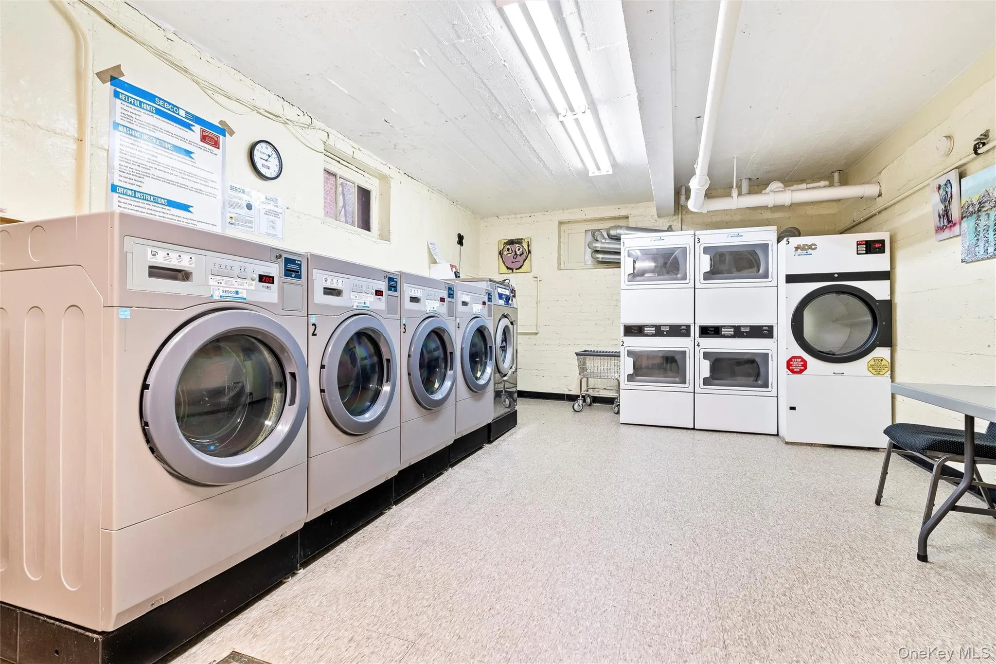 Community laundry room featuring stacked washer and clothes dryer and washer and dryer Community laundry room featuring stacked washer and clothes dryer and washer and dryer