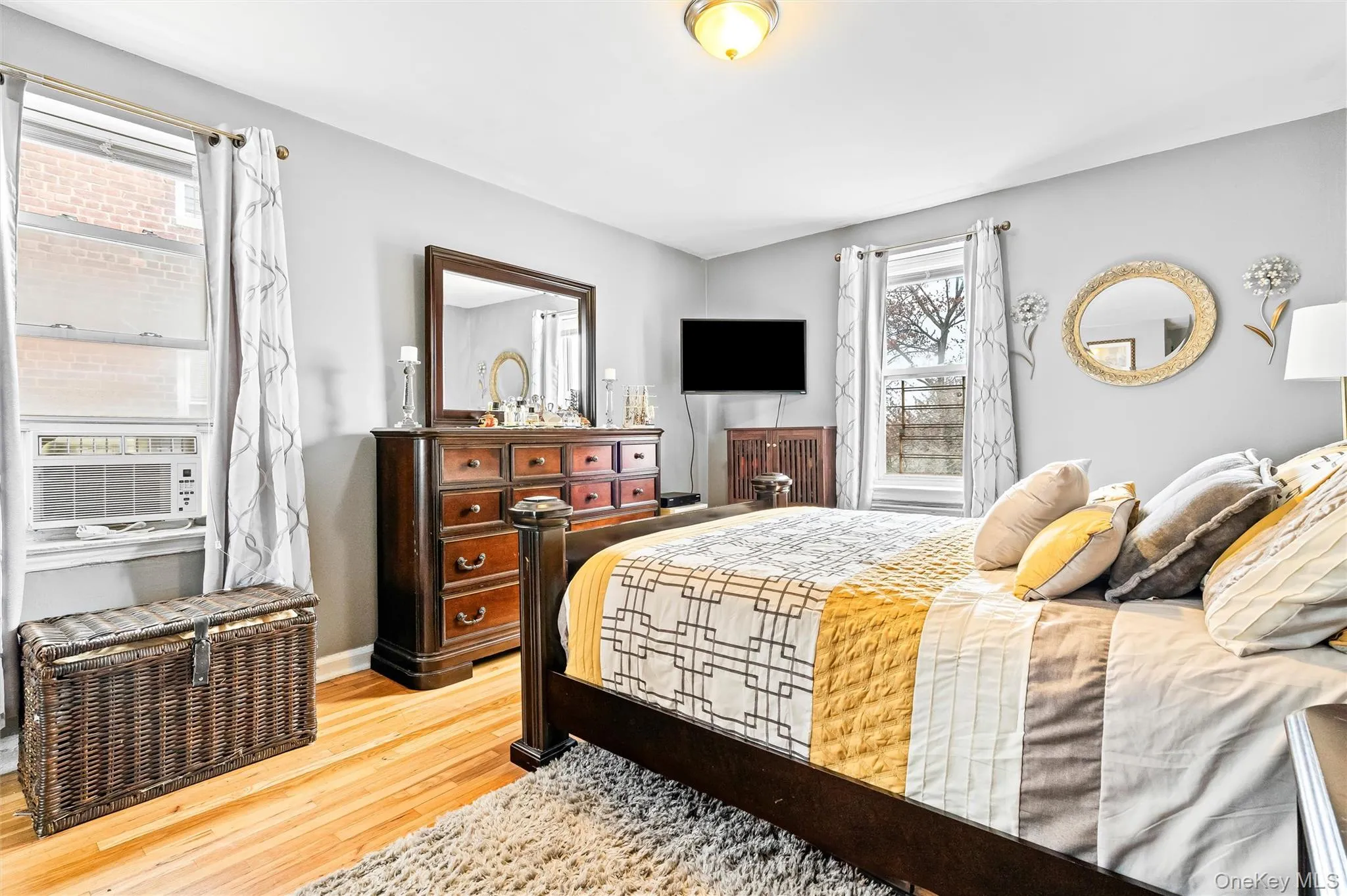 Bedroom with baseboards, cooling unit, and light wood finished floors Bedroom with baseboards, cooling unit, and light wood finished floors