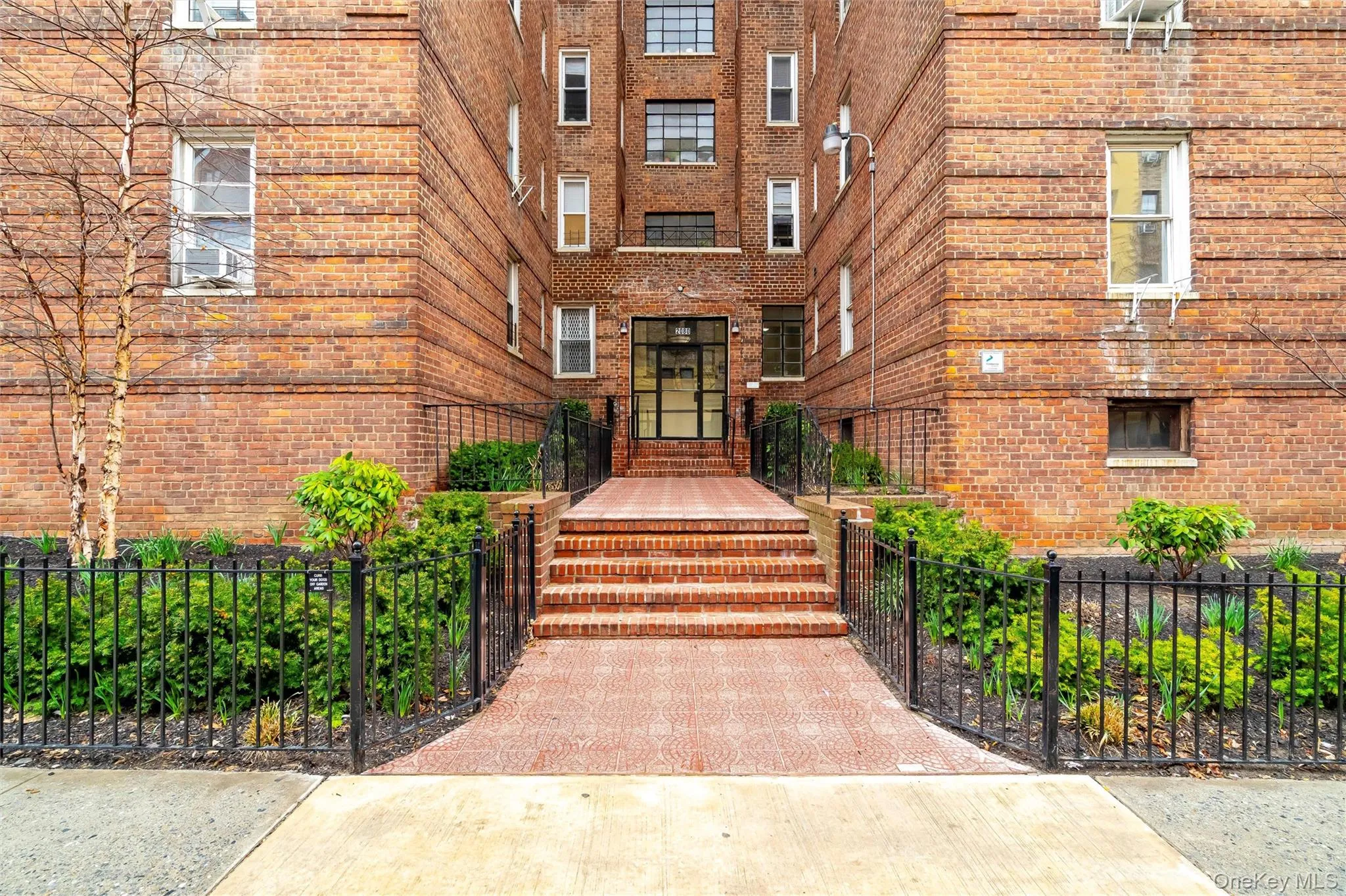 Entrance to property featuring brick siding and fence Entrance to property featuring brick siding and fence