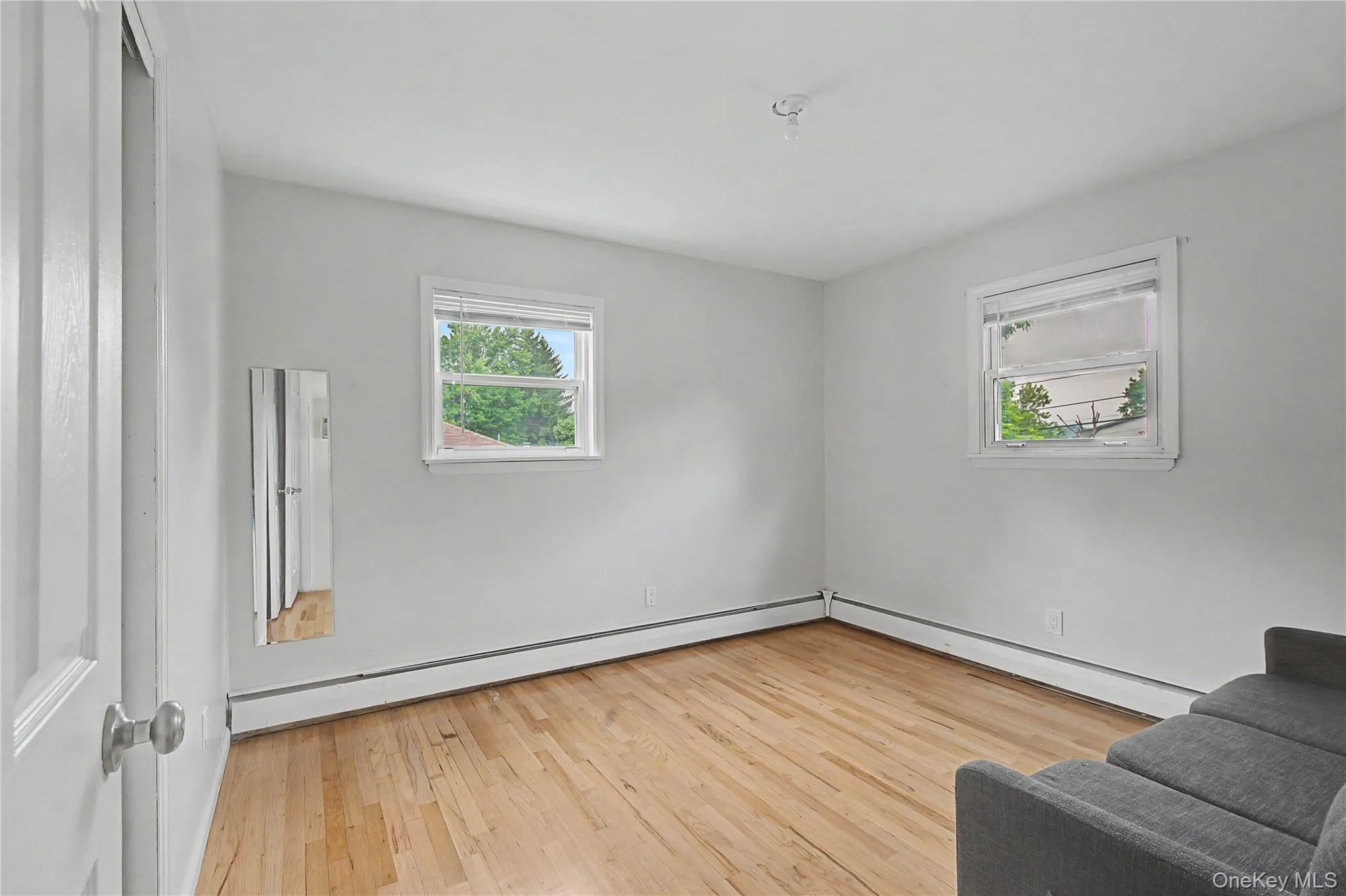 Spacious bedroom with hardwood flooring and a clean, inviting design. Spacious bedroom with hardwood flooring and a clean, inviting design.