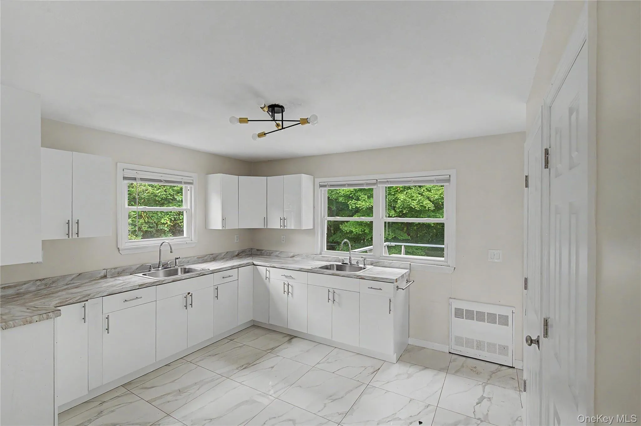 Bright kitchen overlooking a private backyard with peaceful wooded views. Bright kitchen overlooking a private backyard with peaceful wooded views.