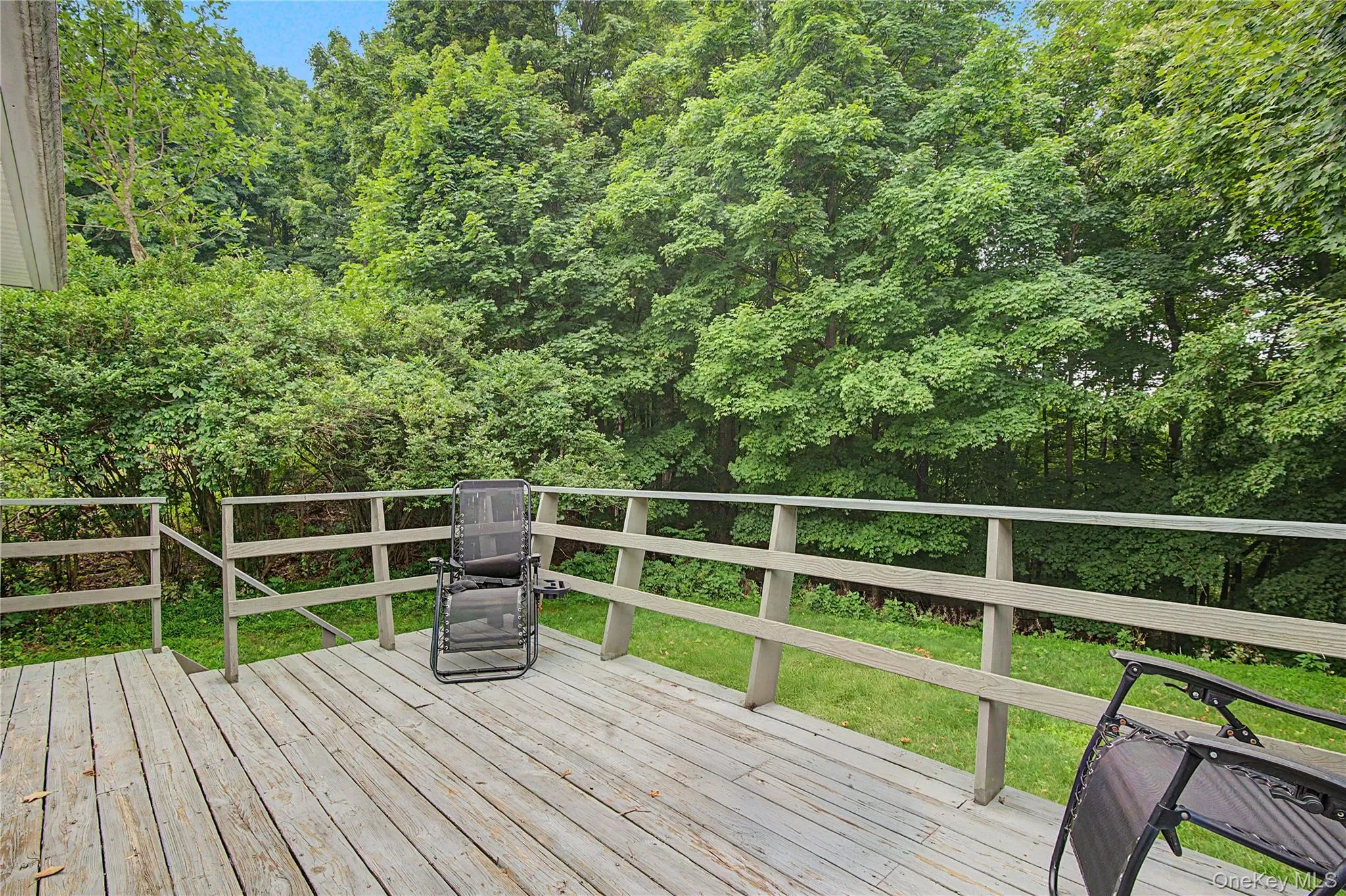 Private deck overlooking a peaceful backyard, ideal for relaxing or entertaining. Private deck overlooking a peaceful backyard, ideal for relaxing or entertaining.