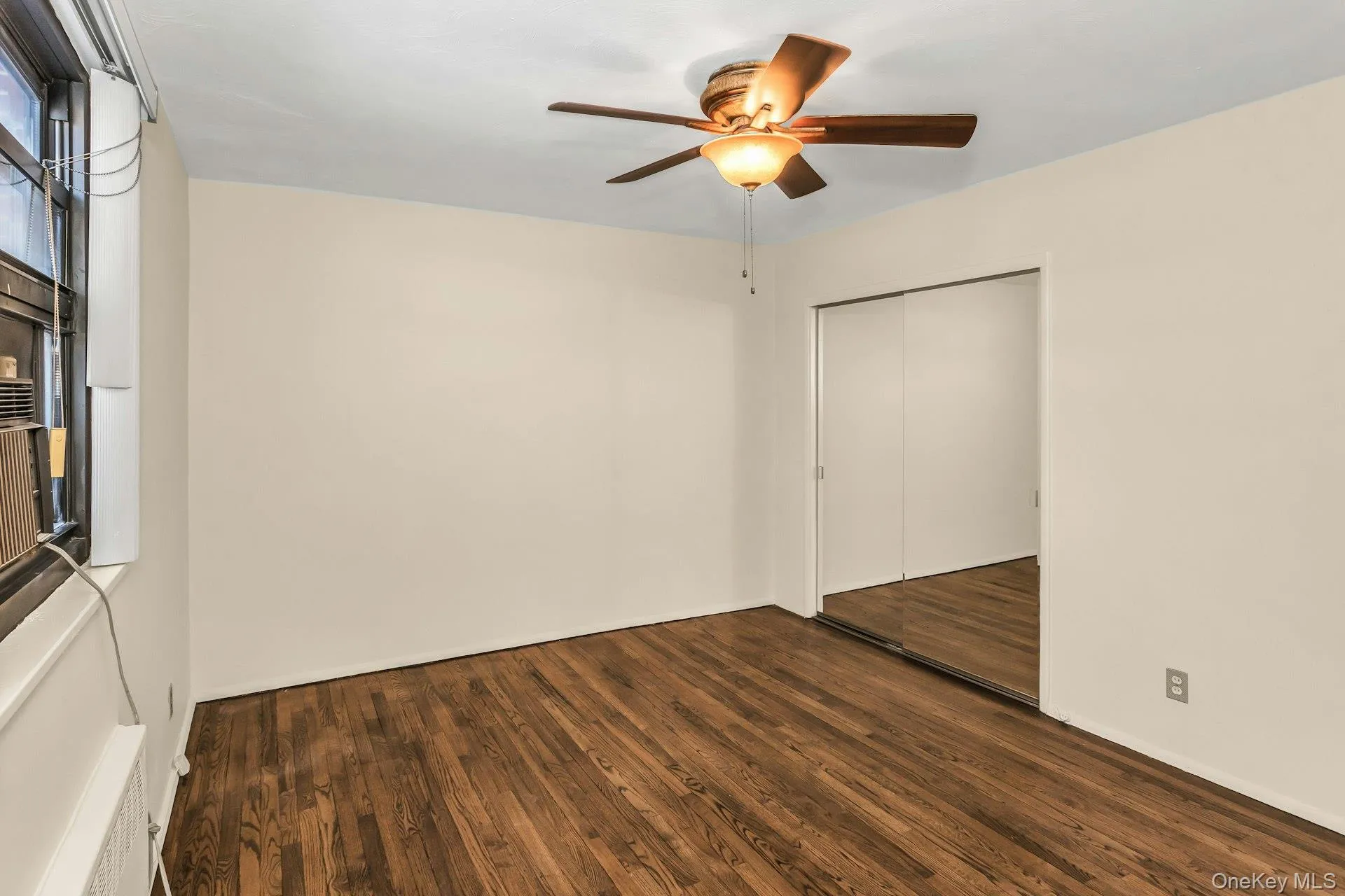 Unfurnished room featuring dark wood finished floors Unfurnished room featuring dark wood finished floors