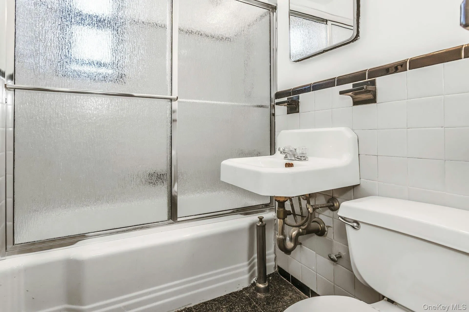 Bathroom with tile walls and bath / shower combo with glass door Bathroom with tile walls and bath / shower combo with glass door