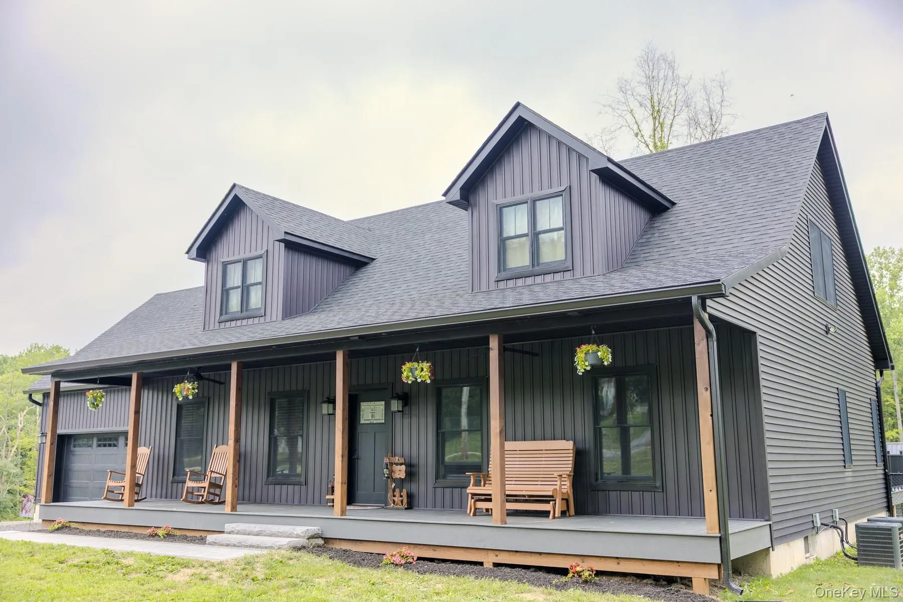 A closer perspective showcases the home's thoughtful craftsmanship, from the warm timber porch posts to the distinctive dormers, and clean board-and-batten exterior. A closer perspective showcases the home's thoughtful craftsmanship, from the warm timber porch posts to the distinctive dormers, and clean board-and-batten exterior.
