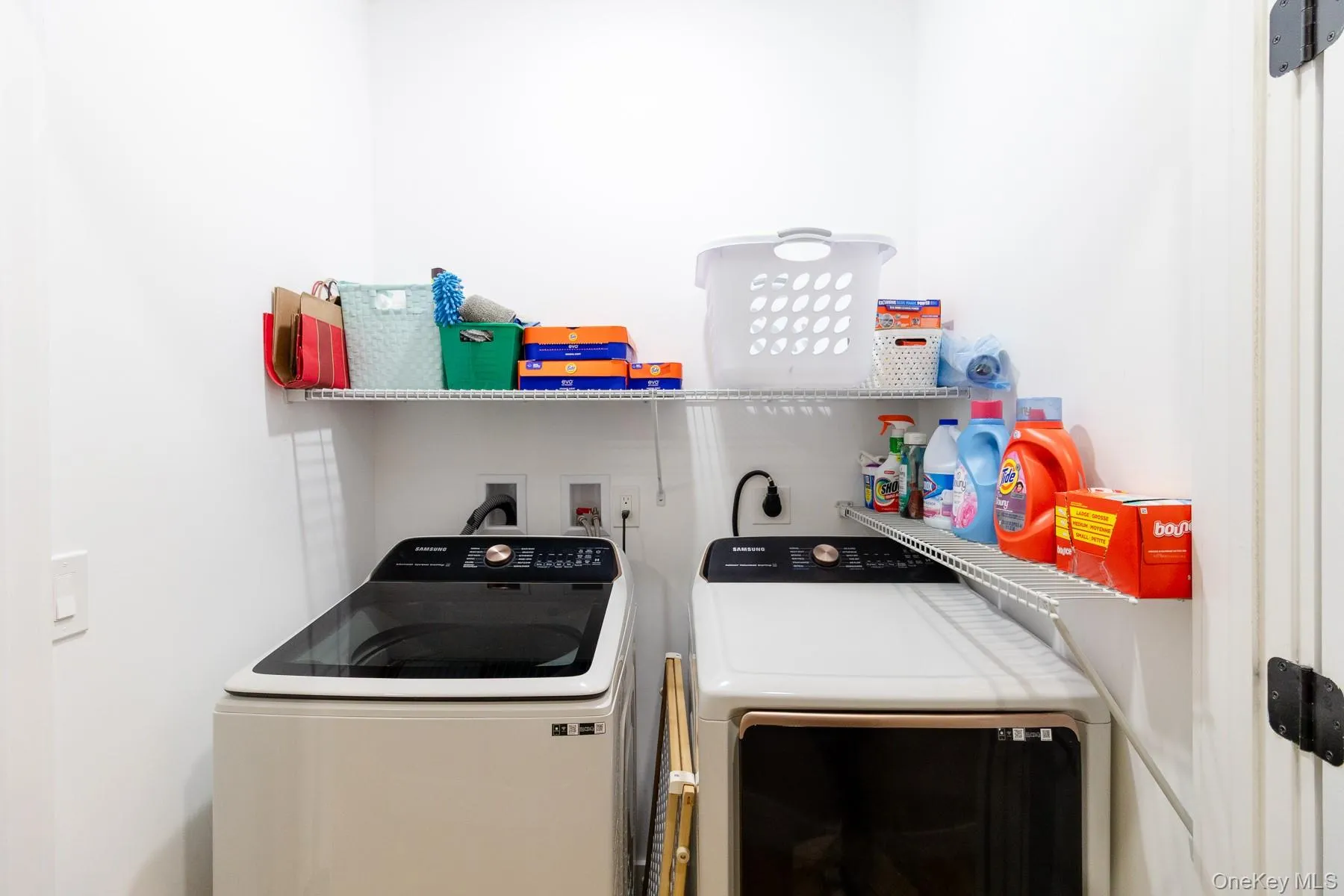 A dedicated laundry room with side-by-side washer and dryer, built in wire shelving to maximize space for supplies within reach and ample storage to keep everyday household tasks organized and convenient. A dedicated laundry room with side-by-side washer and dryer, built in wire shelving to maximize space for supplies within reach and ample storage to keep everyday household tasks organized and convenient.