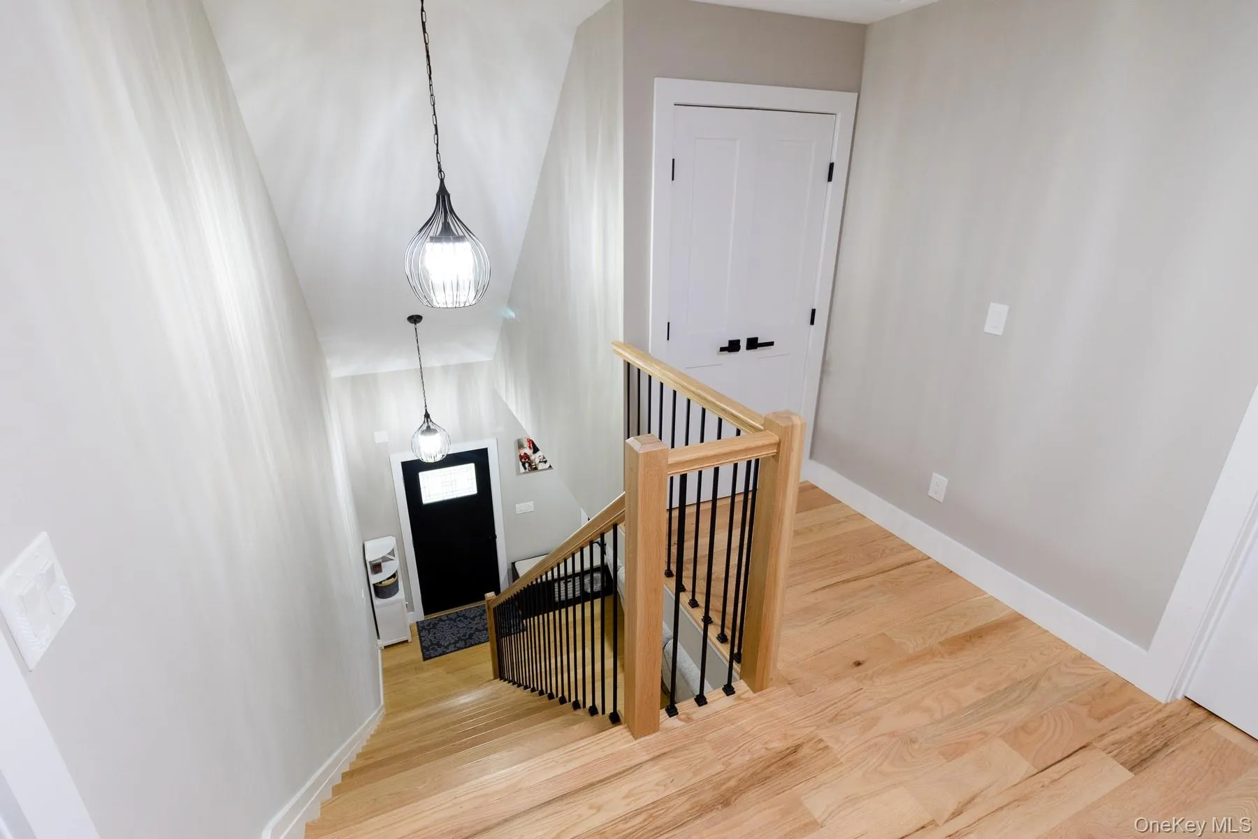 The open staircase is finished with natural wood railings and contrasting black balusters, creating a clean welcoming connection between the home's main and upper living spaces. The open staircase is finished with natural wood railings and contrasting black balusters, creating a clean welcoming connection between the home's main and upper living spaces.