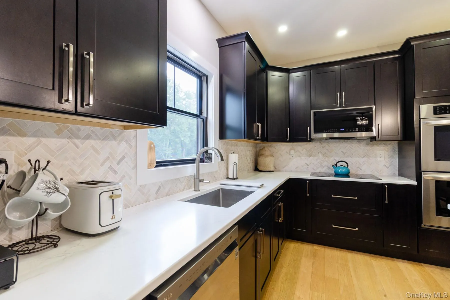 A large picture window fills the kitchen with natural light, creating a bright and inviting space for every day cooking and entertaining. A large picture window fills the kitchen with natural light, creating a bright and inviting space for every day cooking and entertaining.