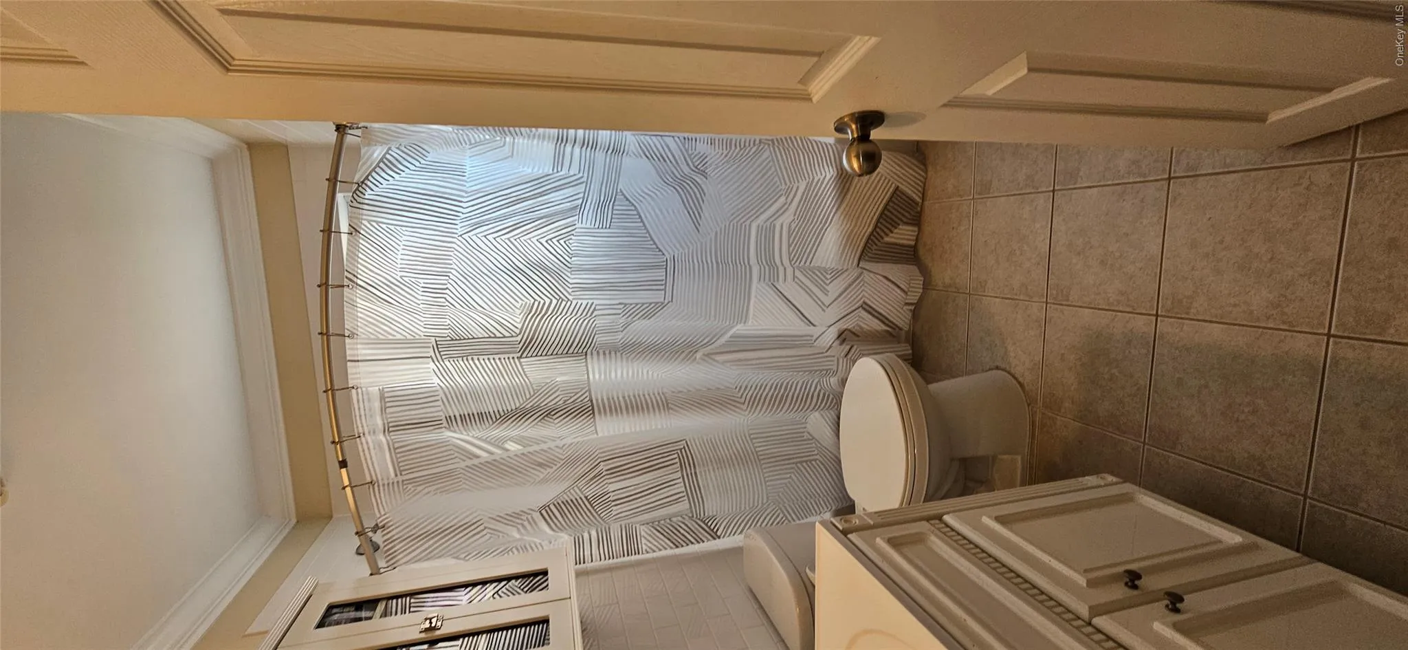 Bathroom featuring vanity, tile patterned flooring, crown molding, and a shower with shower curtain Bathroom featuring vanity, tile patterned flooring, crown molding, and a shower with shower curtain