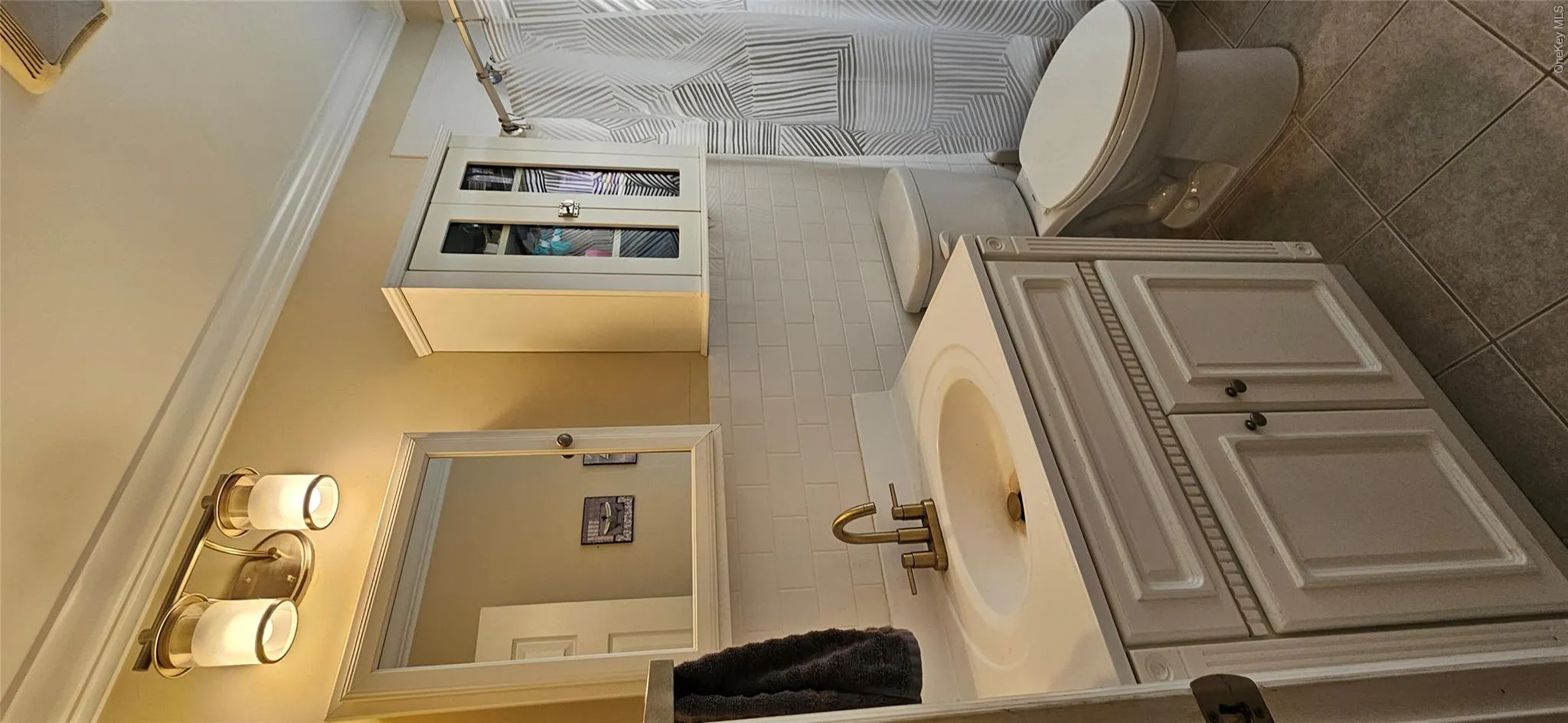 Bathroom featuring tile walls, tile patterned flooring, crown molding, vanity, and a shower with shower curtain Bathroom featuring tile walls, tile patterned flooring, crown molding, vanity, and a shower with shower curtain